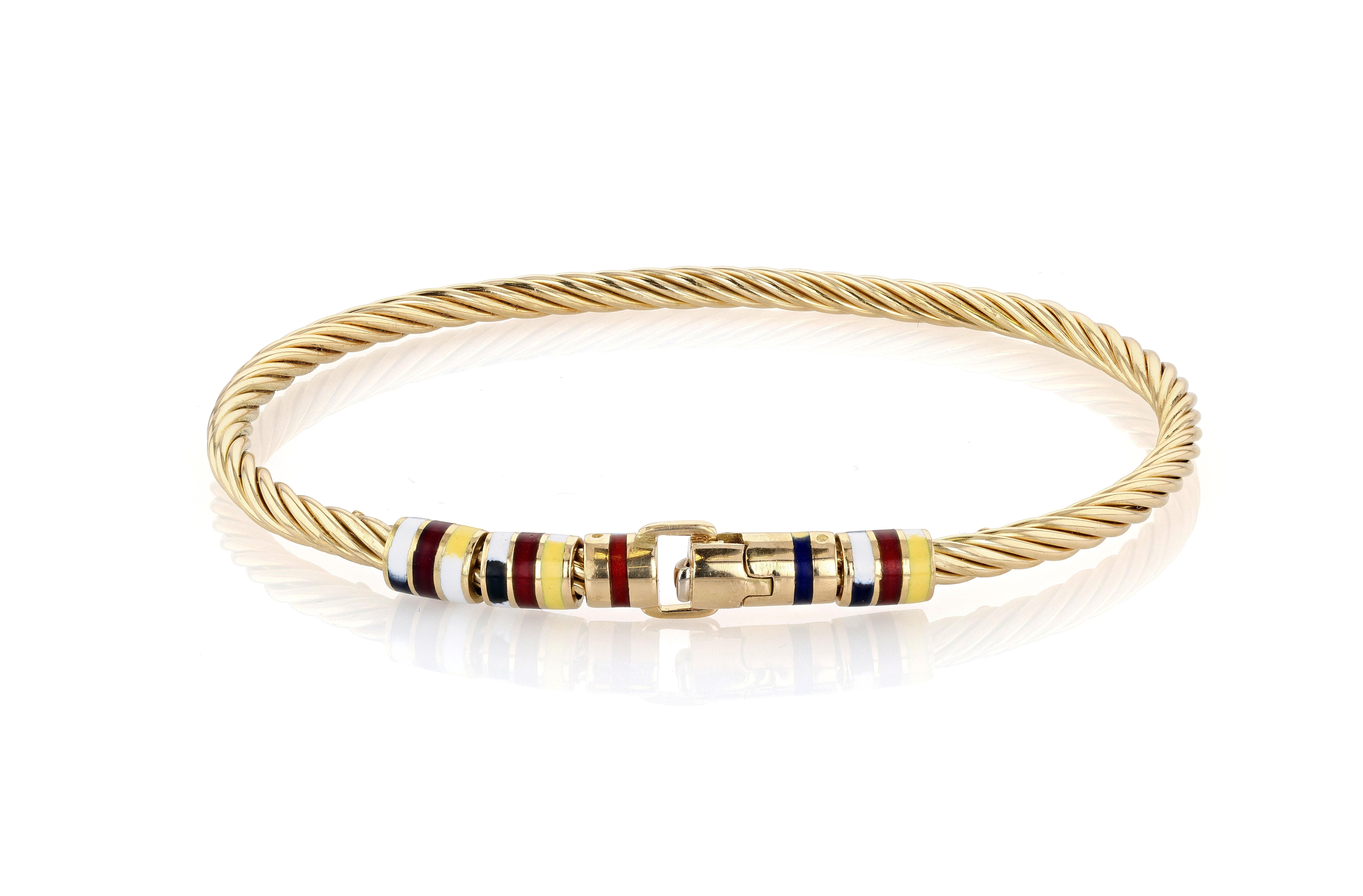 Bracciale vintage in filo d'oro giallo Giovepluvio a 18 carati, dal design fisso e rigido, con numerosi rondel in smalto raffiguranti ciascuno una bandiera nautica. La parte del cavo del braccialetto è rifinita con un motivo a corda e la parte