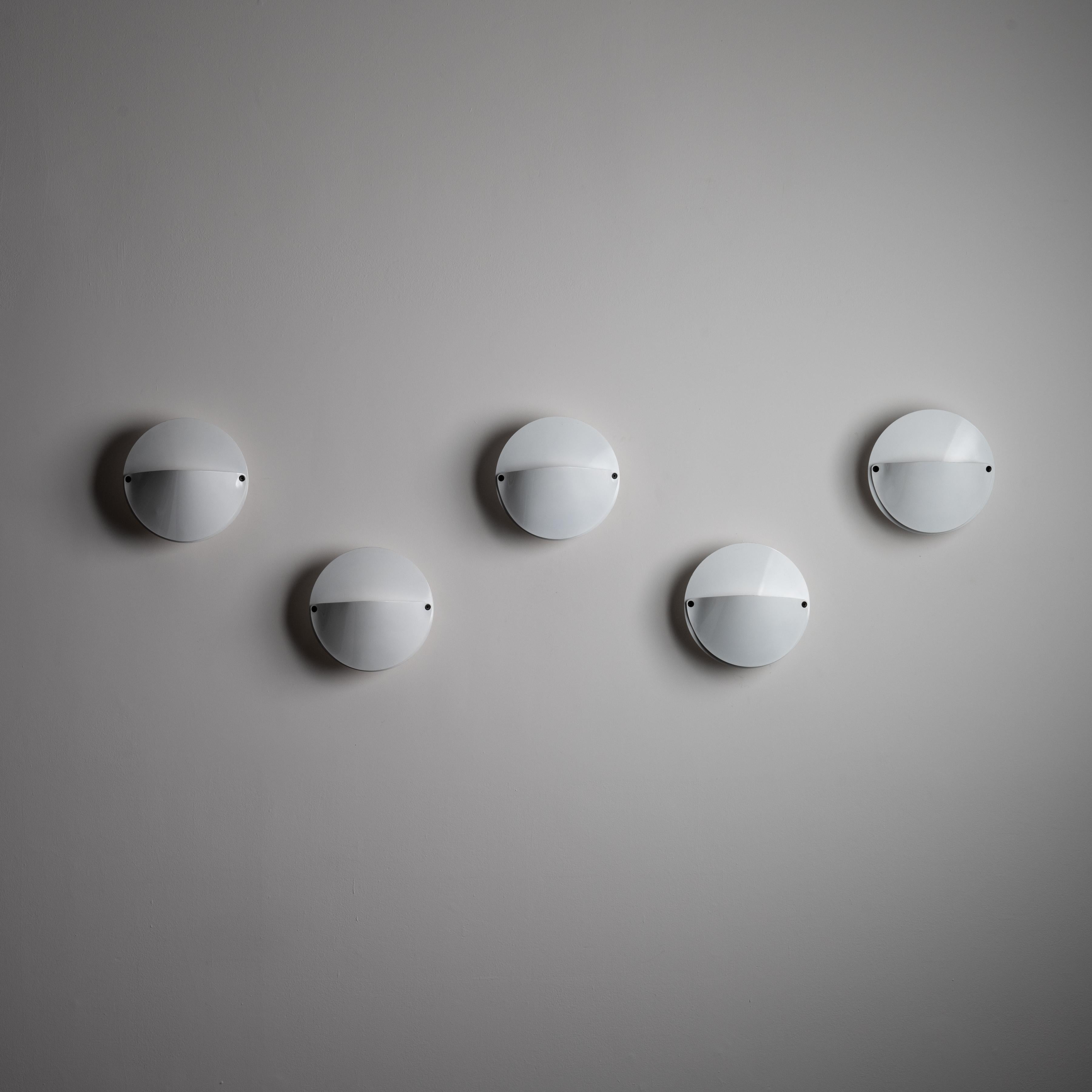 Lampada da sole 'Giovi' di Achille Castiglioni per Flos. Disegnato e prodotto in Italia, intorno agli anni '1970. Applique circolari stravaganti con finitura bianca smaltata e dettagli del collo del corpo aperto dietro la faccia della lampada. Ogni
