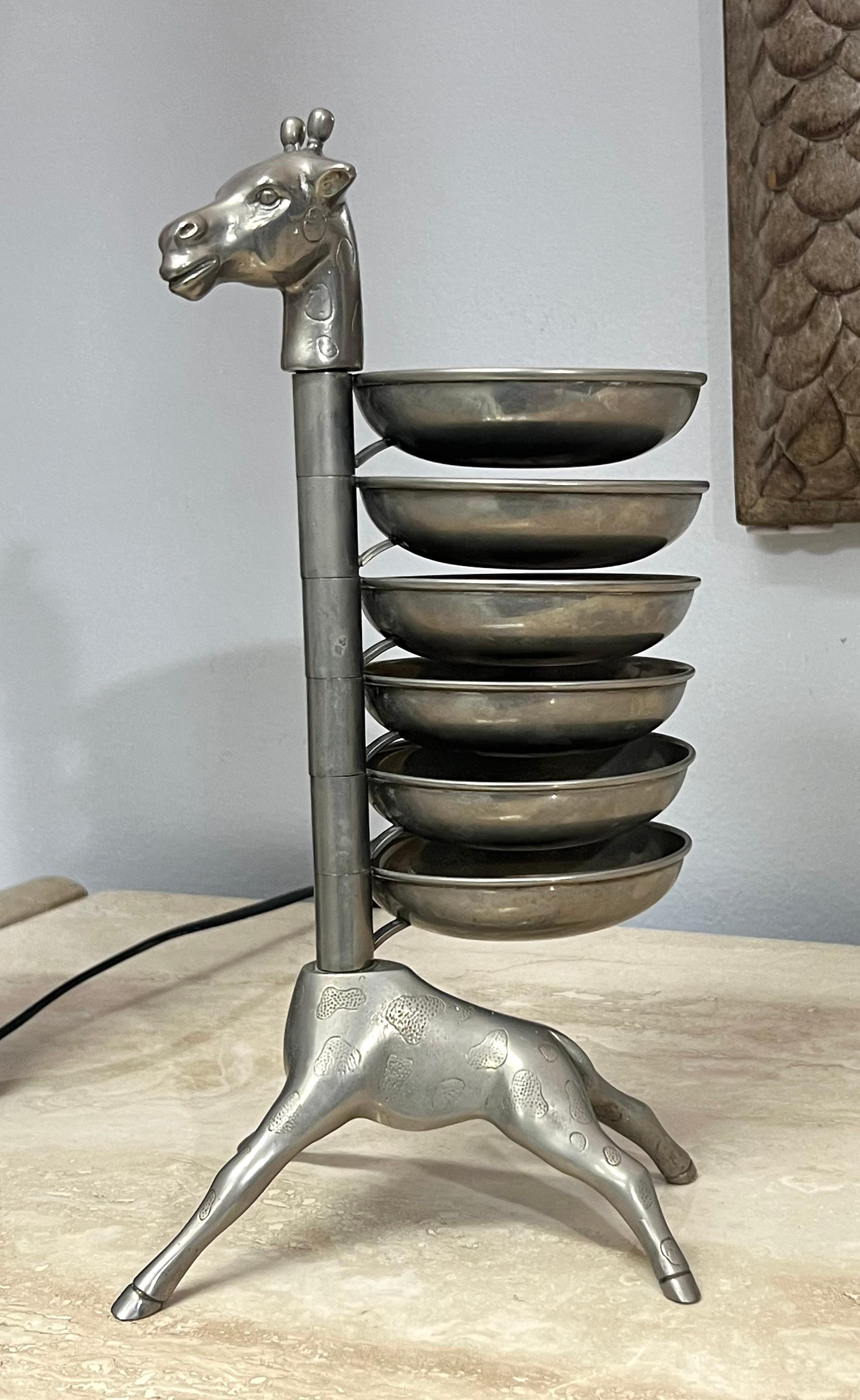 Un piatto da portata a forma di giraffa. Piatti multipli girevoli impalati lungo tutta la lunghezza del collo.