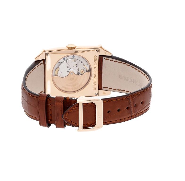 18kt pink gold case with a brown alligator leather strap. Fixed 18kt pink gold bezel. Silver dial with rose gold hands and Arabic numeral hour markers. Minute markers around the outer rim. Dial Type: Analog. Date display between 1 and 2 o'clock