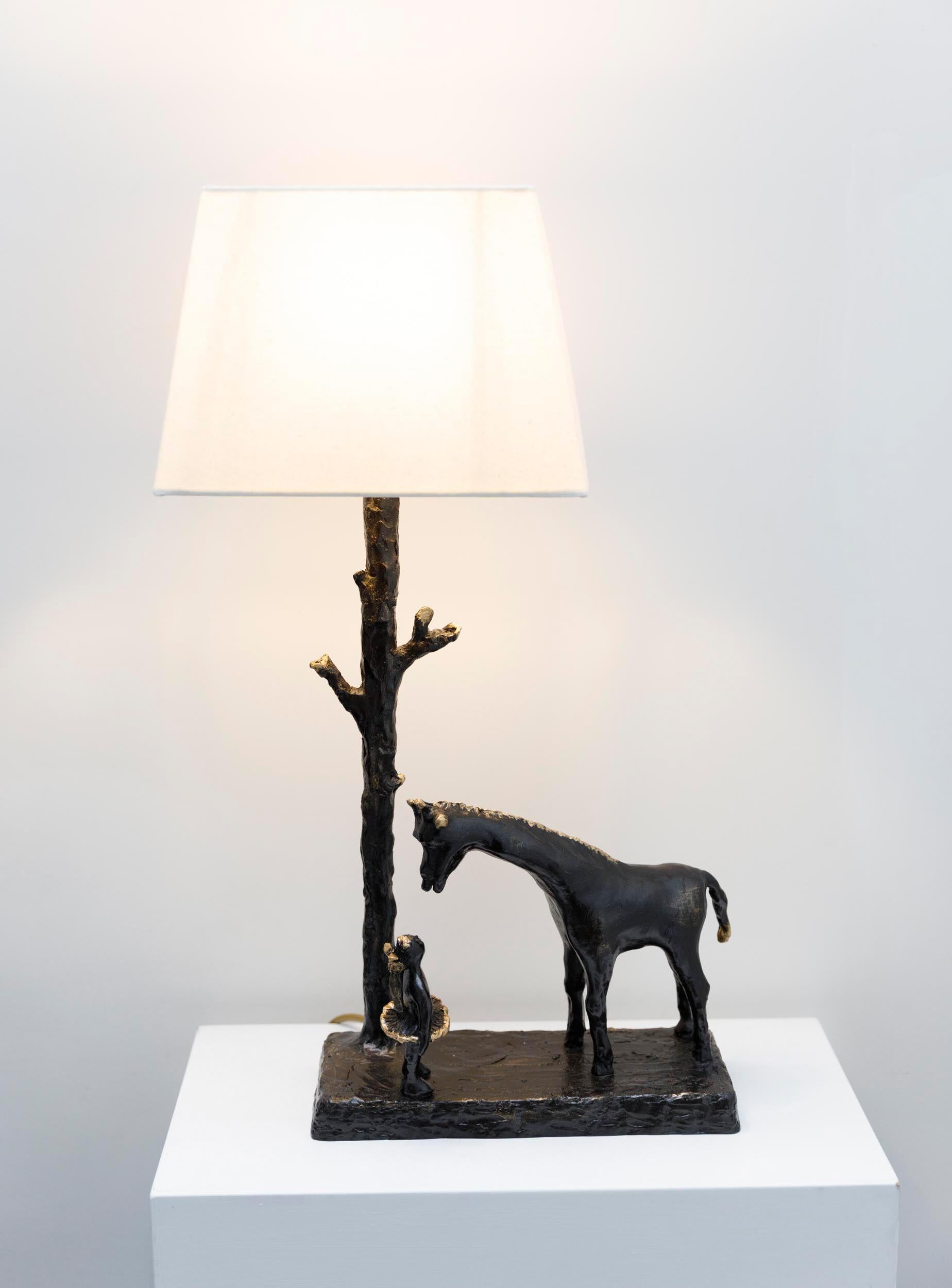 'The Girl and the Giraffe' bronze sculptural table lamp, hand crafted, molded and cast in  bronze in the lost wax process.
A whimsical sculpture lamp of a young girl and a giraffe, engaging in a conversation and captivated by each other;  the girl