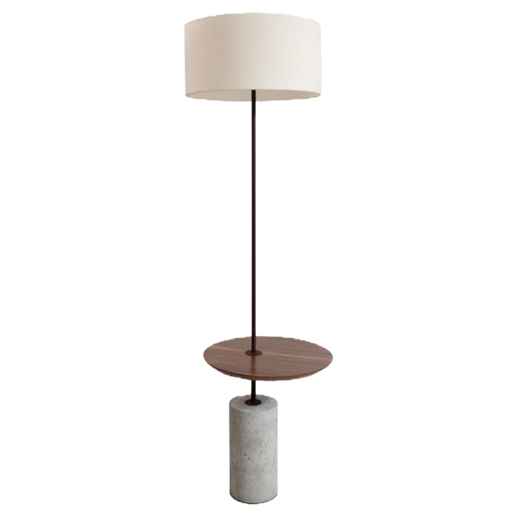Le lampadaire minimaliste Giro (rotation en portugais) joue avec le concept de mouvement et de fonction. Il présente une table d'appoint qui tourne autour de la tige fixée dans un socle en béton afin de pouvoir l'ajuster selon les besoins. La