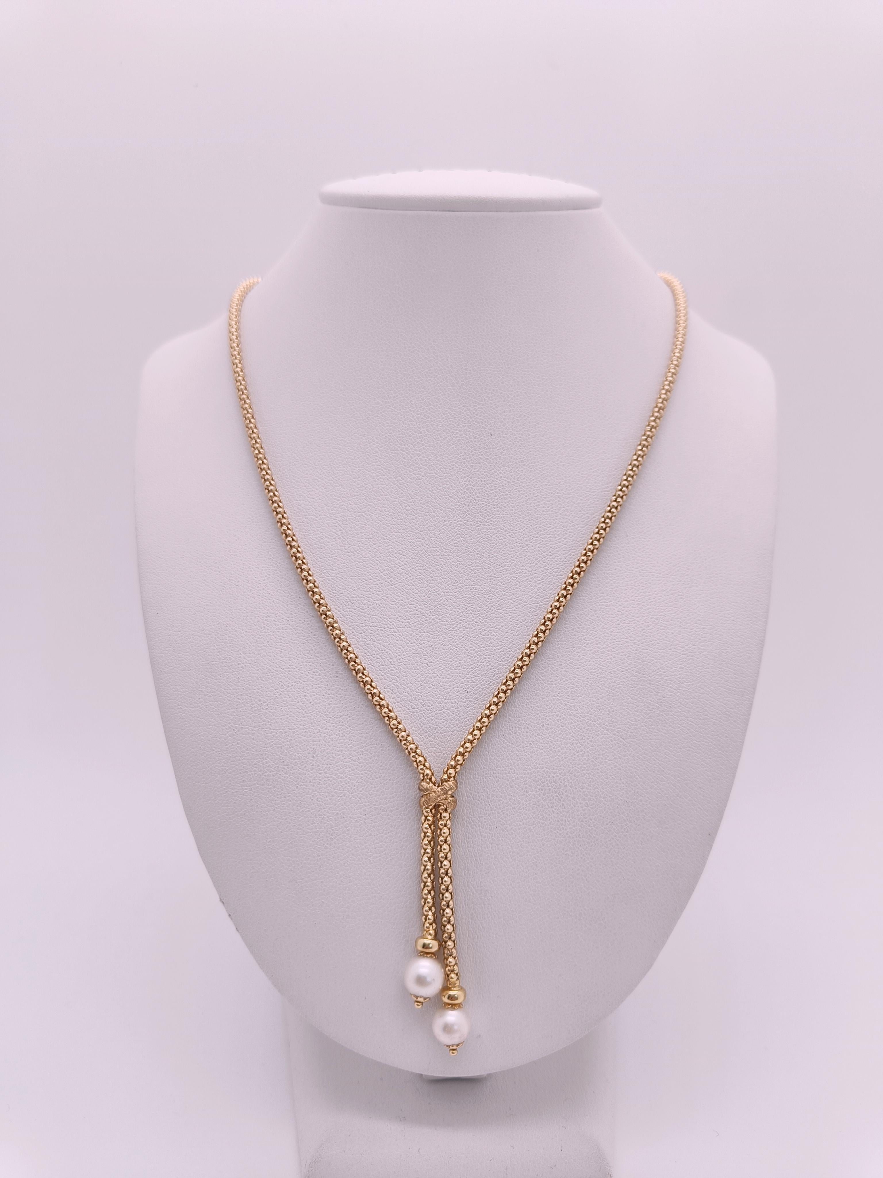 Choker necklace with two pendant tufts with Cultured Pearls.

Entirely made of 18k Gold, a beautiful round and durable mesh, shiny and elegant.
Details include a richly carved knot dividing the choker and tufts ending in two elegant, very bright,