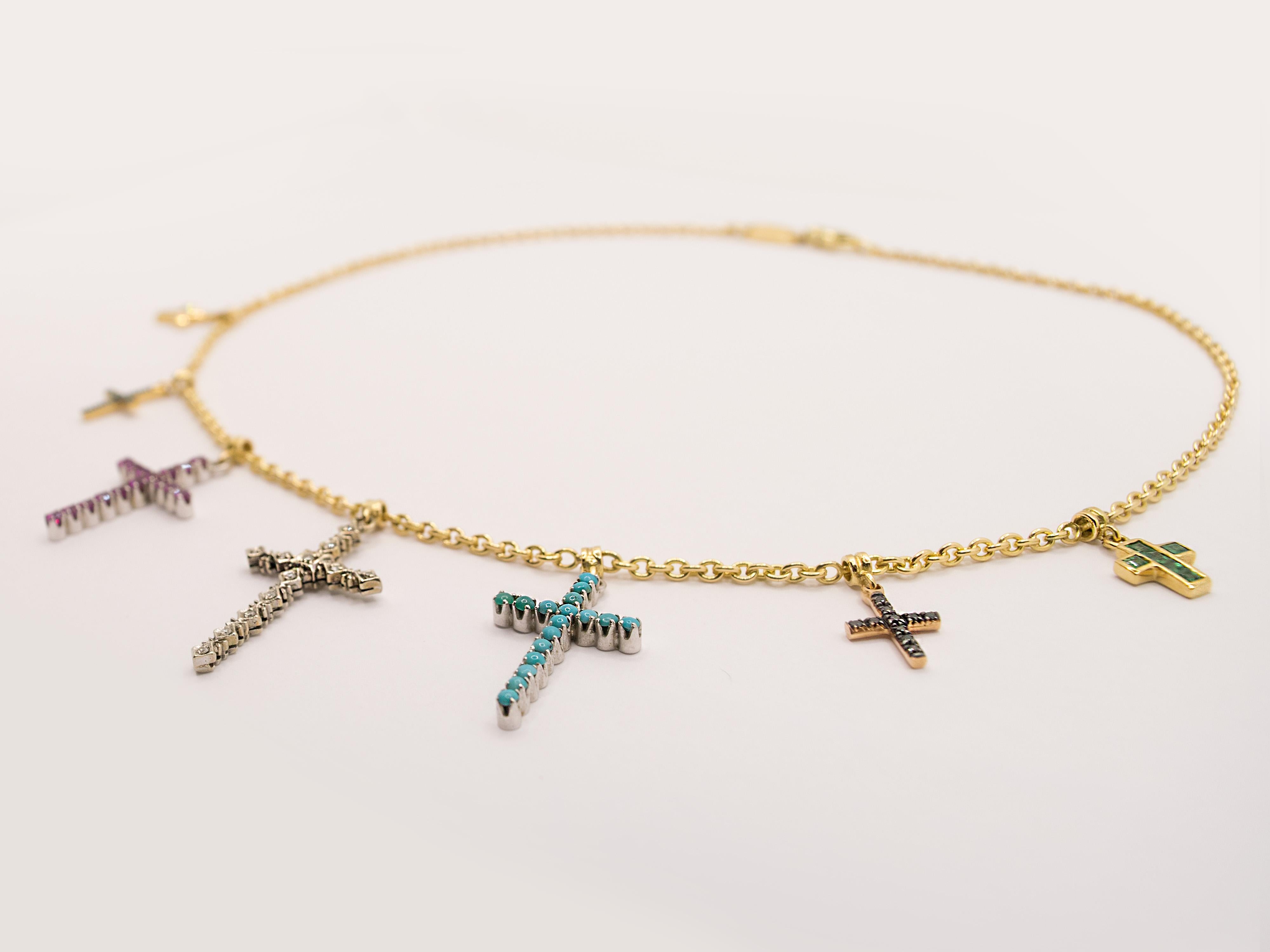 A vintage 18kt yellow gold choker embellished with seven crosses.
These pendants range in size from 0.90x0.70 cm to 3x2 cm.
In order these pendants are yellow gold and carré-cut diamonds, rose gold and tsavorite, white gold and rubies, white gold