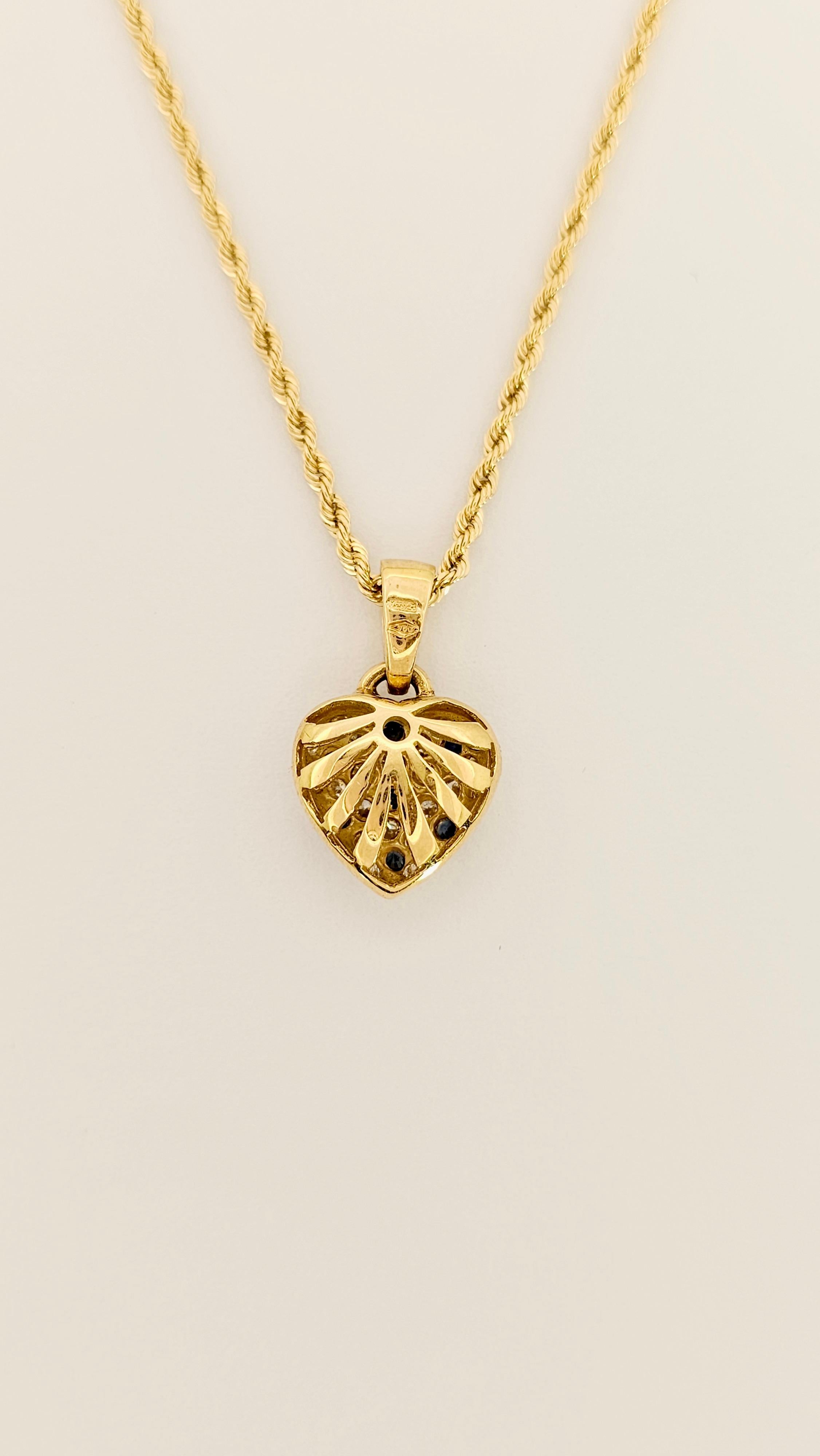 A pendant necklace made of 18 kt gold.
This choker consists of a rope-link chain and a domed heart-shaped pendant in 18kt gold and pavéed with White Diamonds and Blue Sapphires.
This pendant is handcrafted, the weight of the Diamonds is 0.36 carats