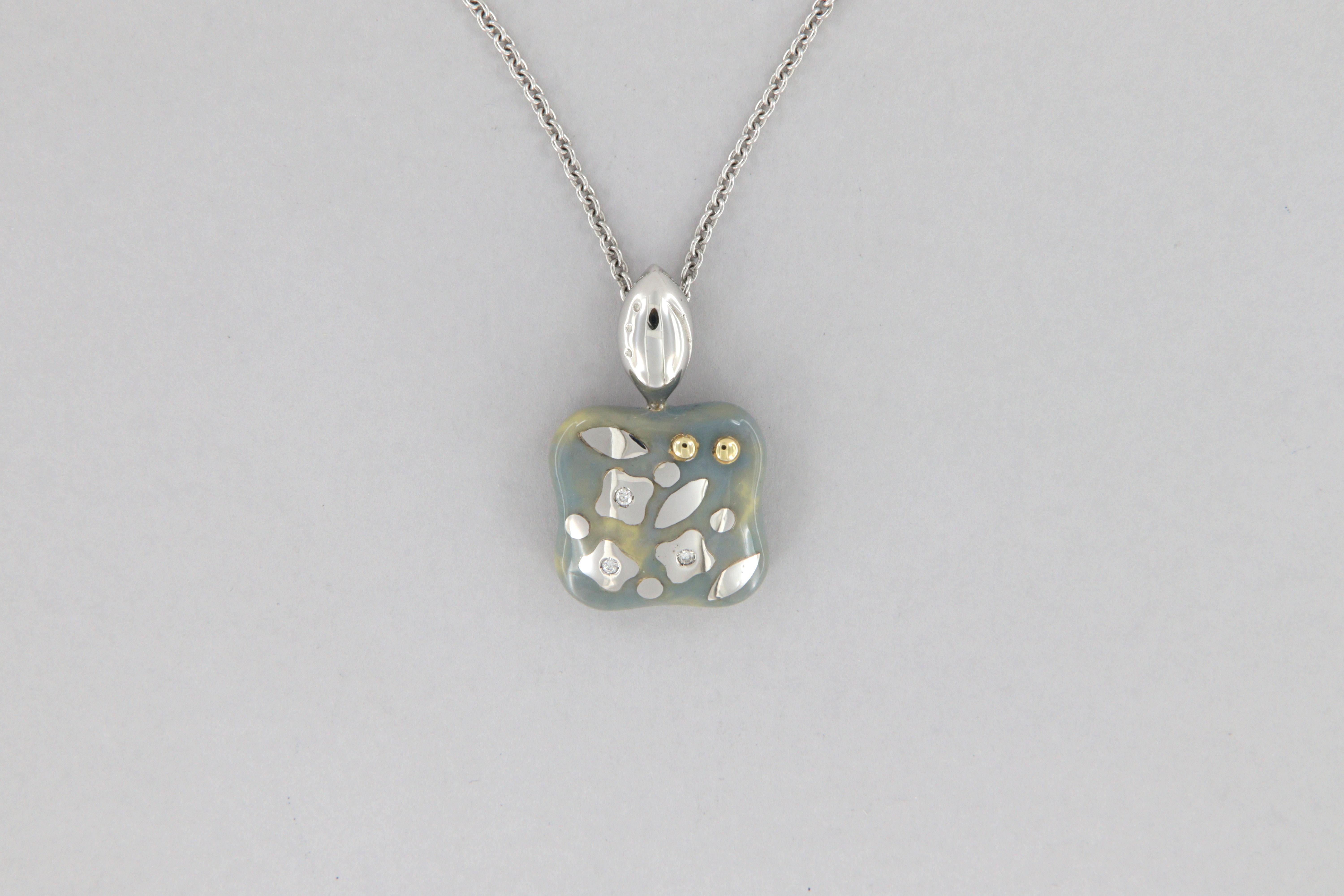 Girocollo La Nouvelle Bague in oro 18 kt, smalto e diamanti, prodotto nel 2000 ca.
Il girocollo è costituito da una catenina sottile in oro bianco ed un ciondolo quadro con smalto lilla sfumature crema, decorato con 03 diamanti rotondi taglio