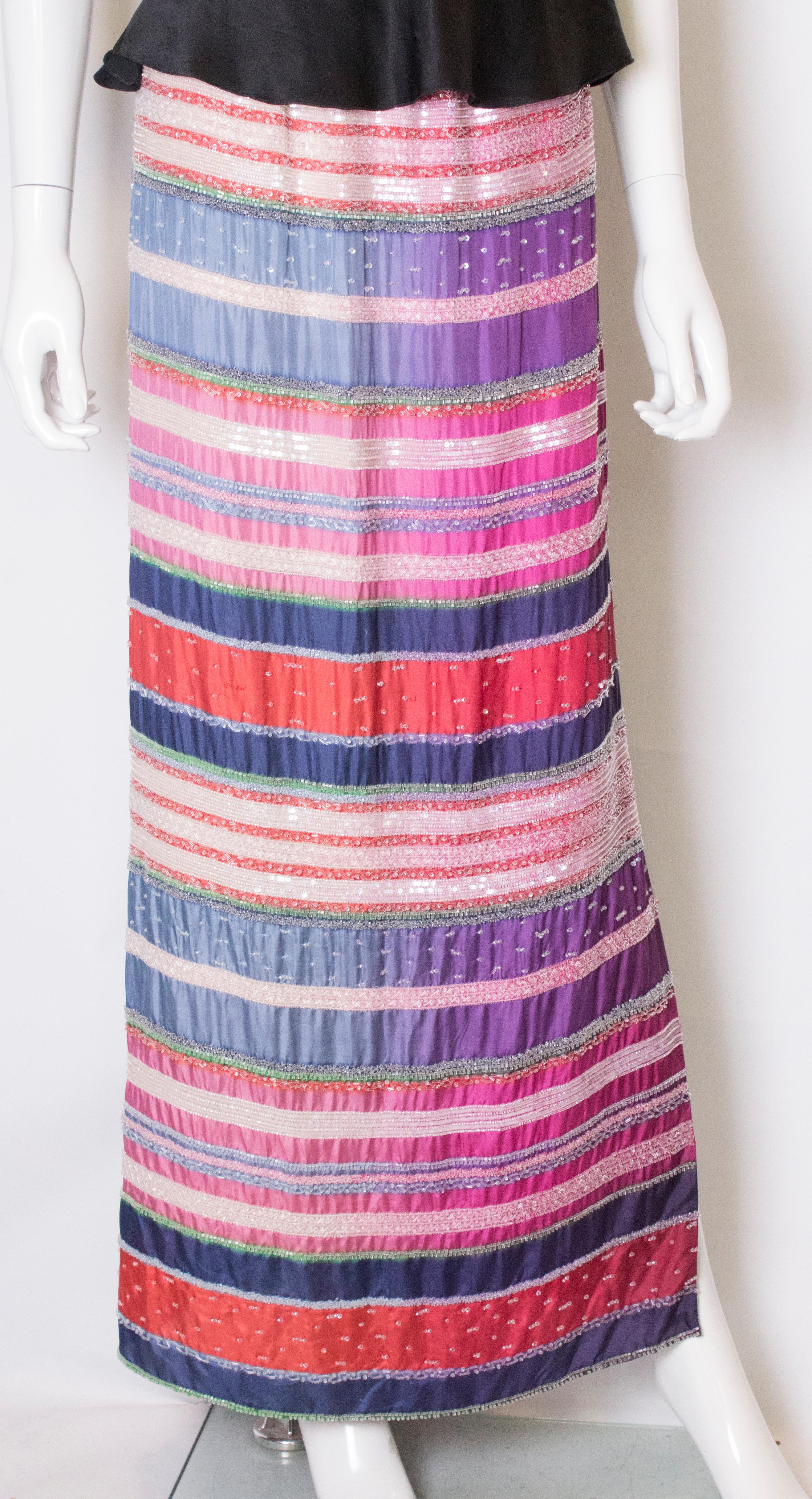 A stunning silk skirt by Giorgio Armani. In a wonderful mix of colours and bead work,  the skirt is lined in silk and has a 25'' slit on one side.