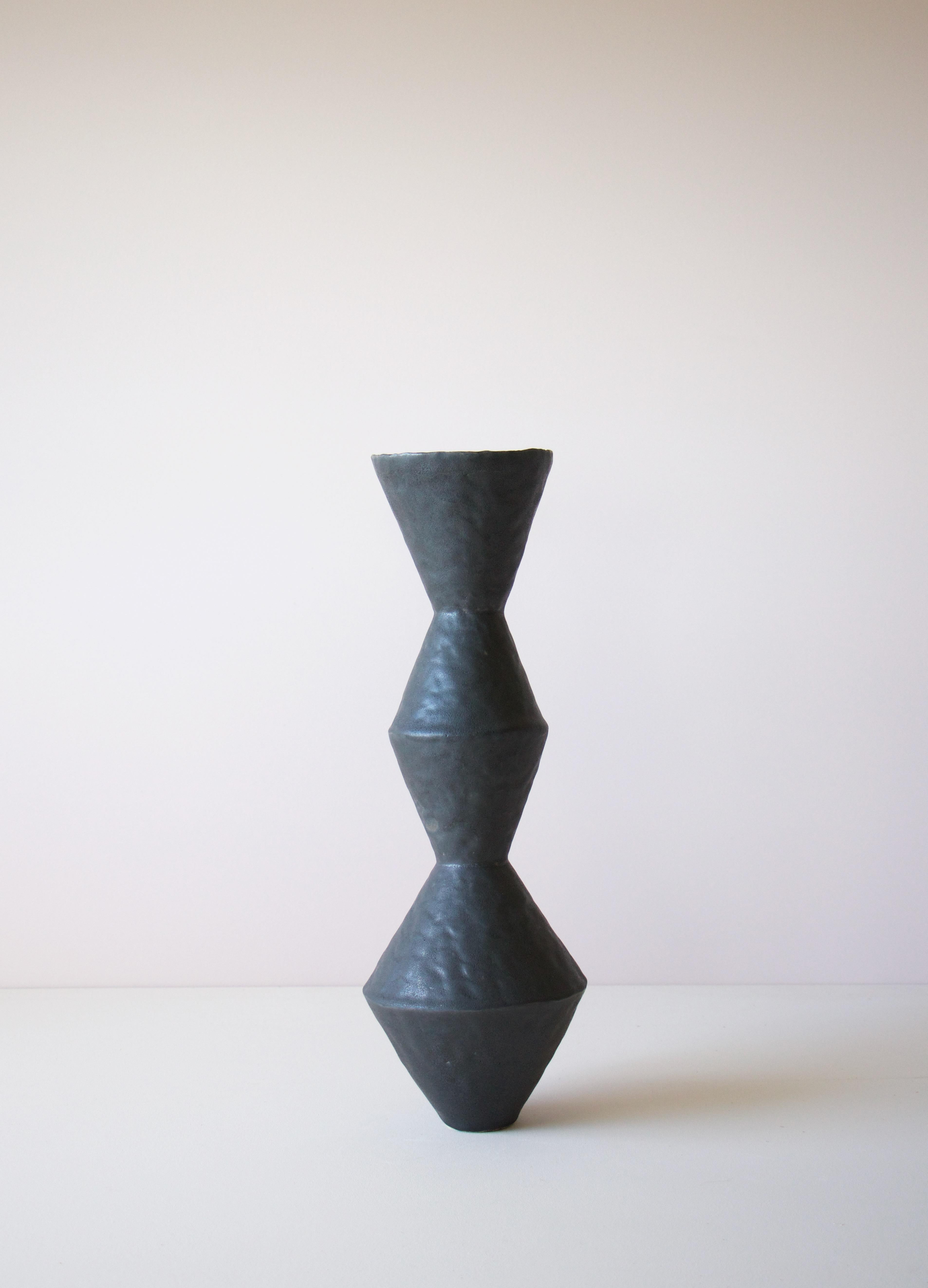 Contemporary American ceramic artist Giselle Hicks' glazed black stoneware vase is part of her Vessel series. Each form is built by hand using a coil and pinch technique. They are formal explorations in shape, volume, color and composition. The