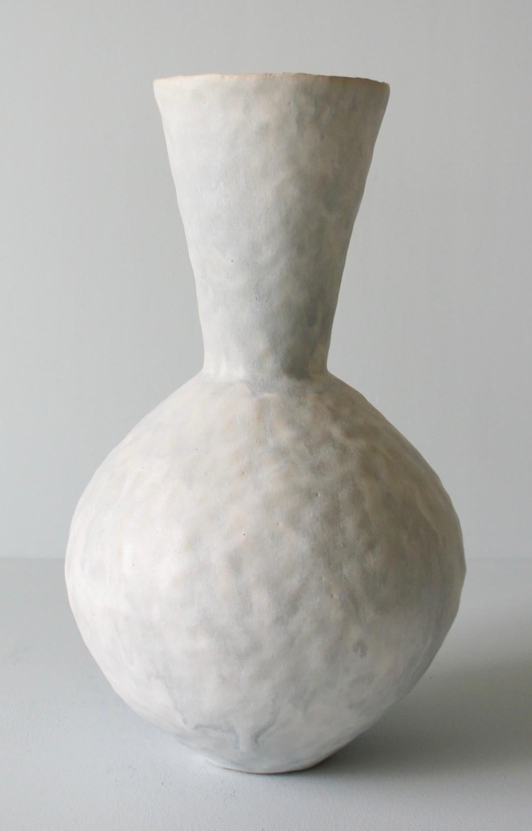 Contemporary American ceramic artist Giselle Hicks' glazed pale grey stoneware vase is part of her Vessel series. Each form is built by hand using a coil and pinch technique. They are formal explorations in shape, volume, color and composition. The