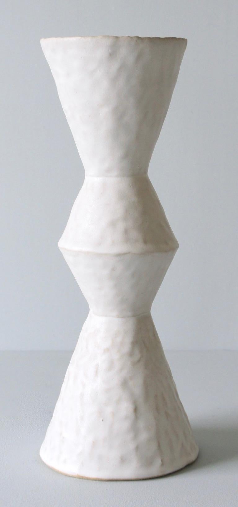 Contemporary American ceramic artist Giselle Hicks' glazed white stoneware vase is part of her Vessel series. Each form is built by hand using a coil and pinch technique. They are formal explorations in shape, volume, color and composition. The