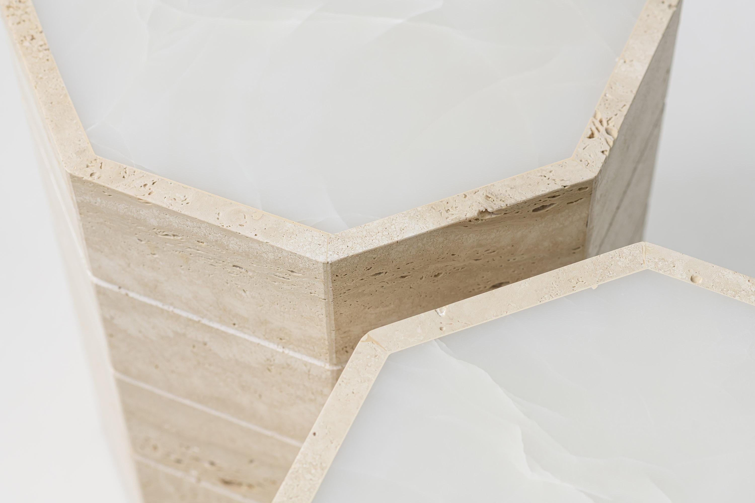 **Gisou - Una mesa auxiliar inspirada en el misterio y la arquitectura**

La mesa auxiliar Gisou es una pieza única inspirada en la cerradura de criptex, símbolo de protección y secreto. Su diseño escultórico en travertino crudo, marcado por estrías