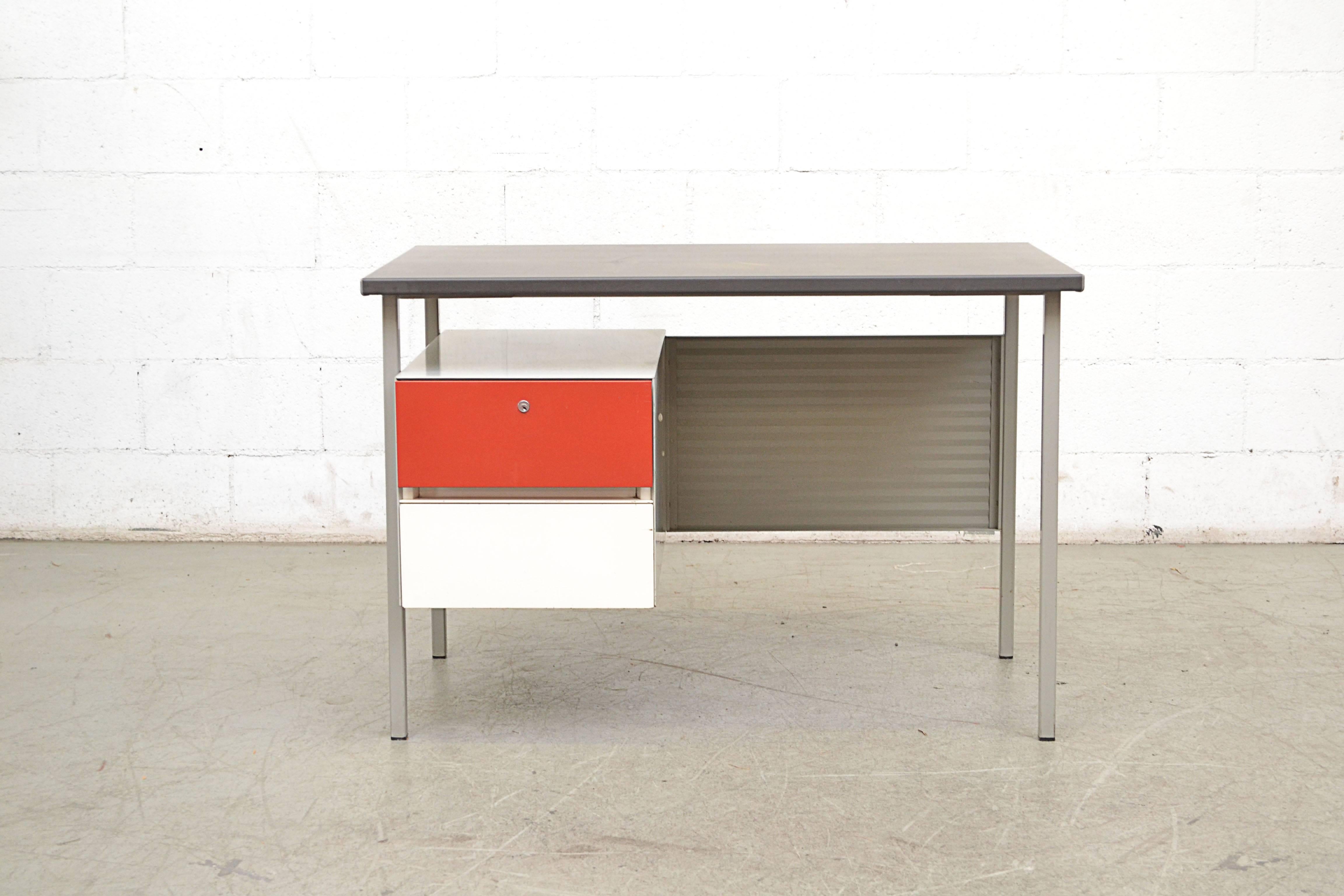 Midcentury industrial metal desk by A. R. Cordemeyer for Gispen. Light grey enameled metal desk with corrugated metal privacy screen, red and white enameled metal drawers and grey linoleum top. No key: (Visible Wear, Some Scratching and Metal Loss.