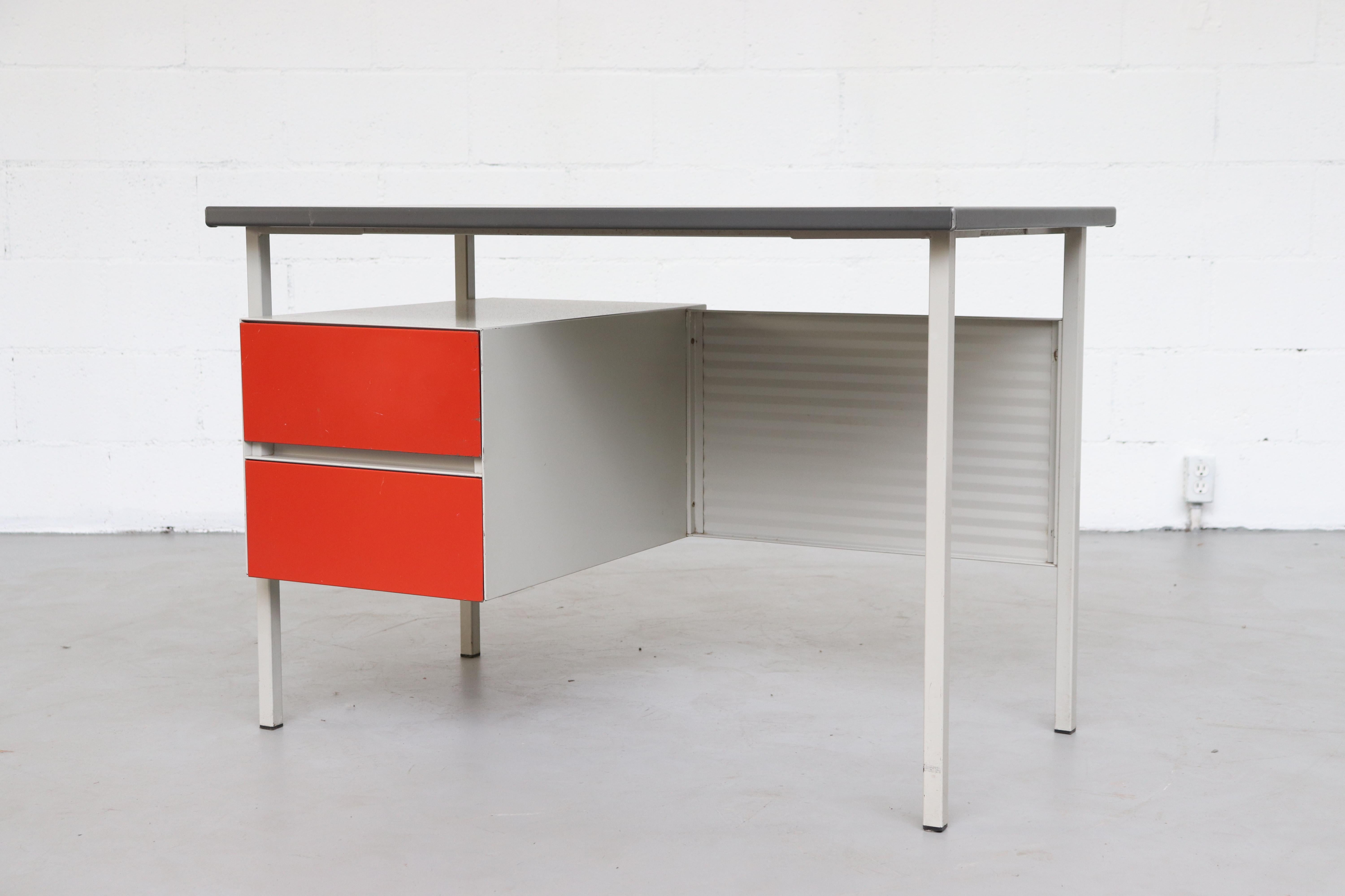 Midcentury Industrial metal desk by A. R. Cordemeyer for Gispen. Light grey enameled metal desk with corrugated metal privacy screen, red enameled metal drawers and grey linoleum top. Visible wear, some scratching and metal loss. Wear is consistent