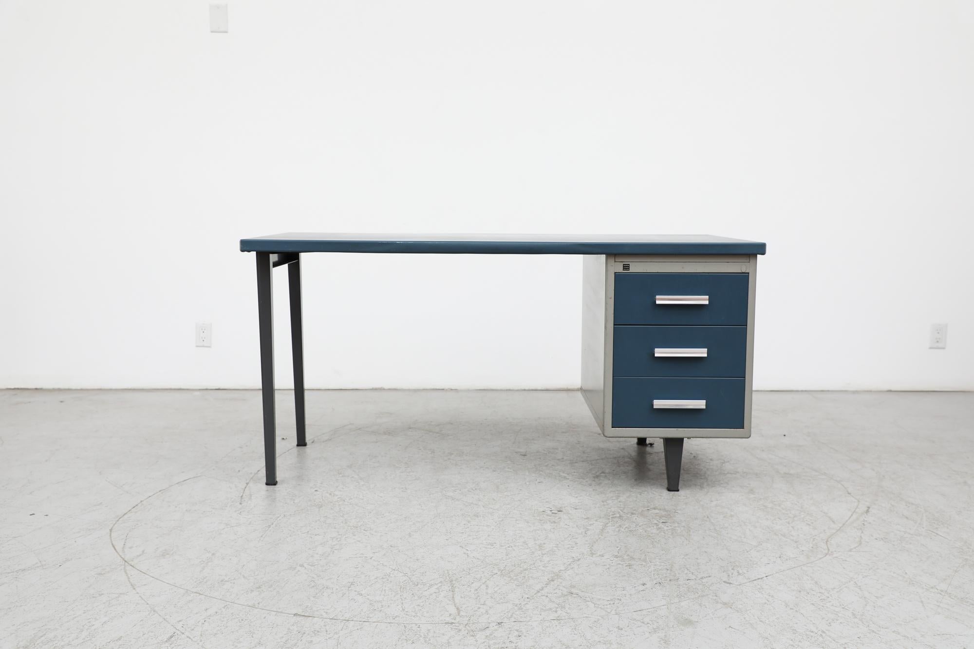 Bureau industriel Gispen avec tiroirs bleus, plateau en linoléum bleu et cadre en métal émaillé gris. Fait partie de la ligne de mobilier de bureau 