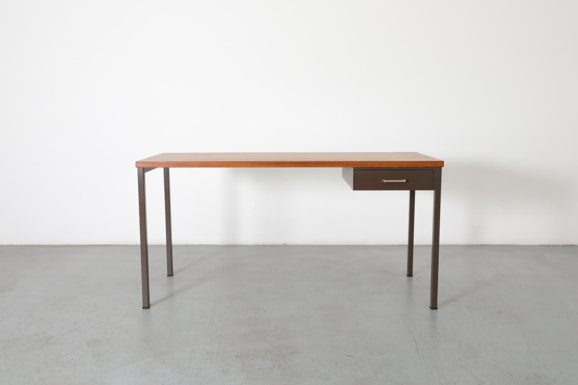 A rare Gispen industrial style desk with chocolate enameled metal frame and teak wood top. Classically constructed with a single side stacked enameled metal drawer. In original condition with some surface scratching and enamel loss consistent with