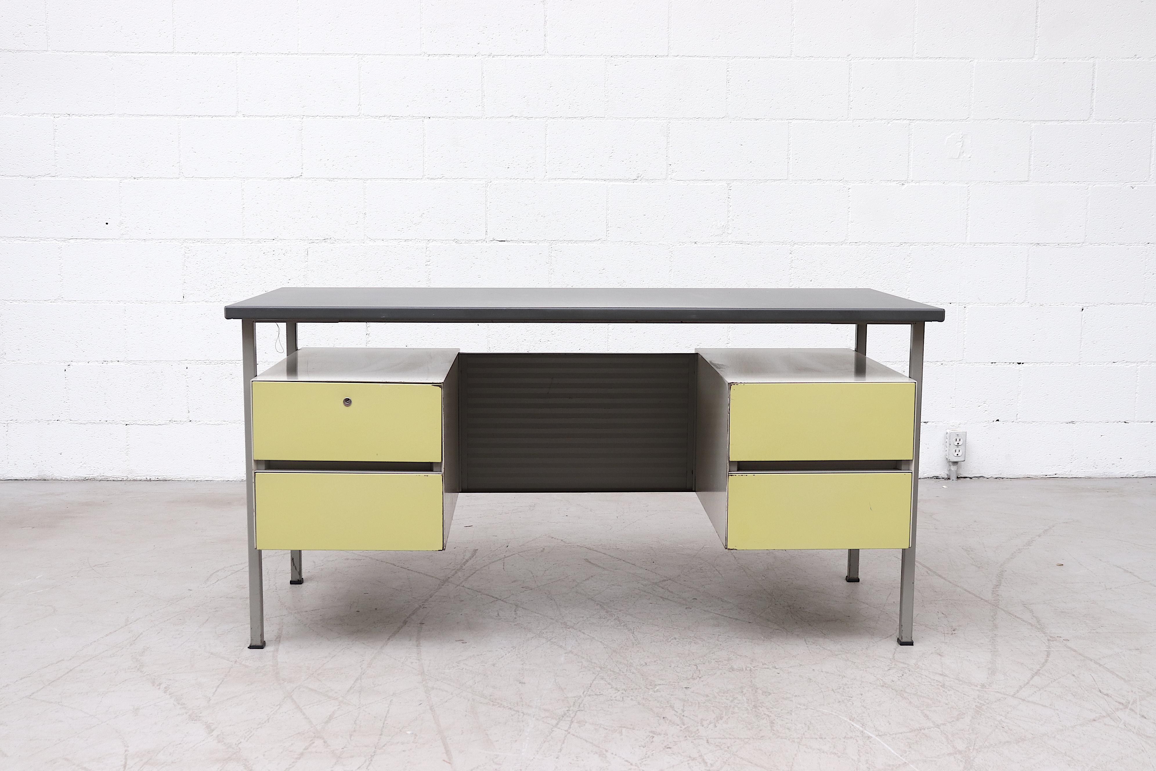 Gispen Industrial writing desk by A.R. Cordemeyer with double stacked chartreuse enameled drawers, a corrugated privacy screen and charcoal grey linoleum top. In original condition with visible wear and key. Wear is consistent with its age and usage.