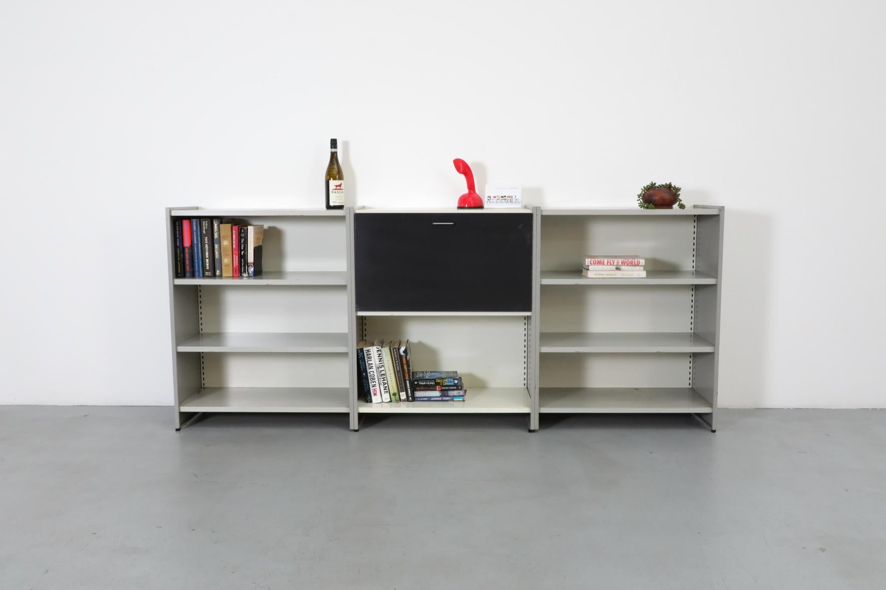 A.R. Libreria e mobile industriale a 3 sezioni in metallo smaltato grigio Cordemeyer con armadio a ribalta al centro. Perfetto per essere utilizzato come libreria, credenza o come bar con un ulteriore spazio di archiviazione. Il leggendario design