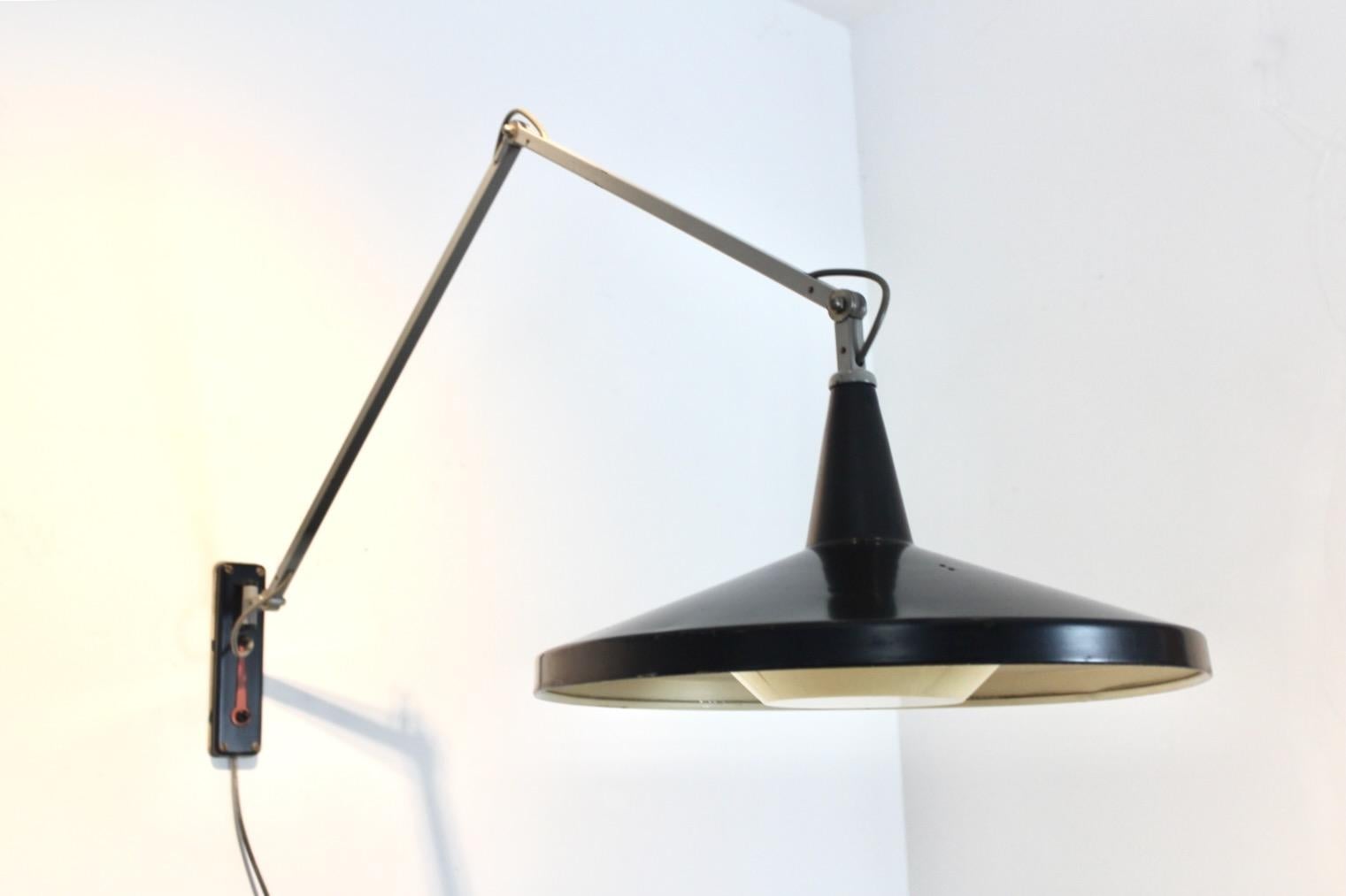Raffinato esempio di industrial design olandese del dopoguerra, questa lampada da parete Gispen Panama originale n. 4050 è stata progettata negli anni '50 da Wim Rietveld e André Cordemeyer per Gispen. Questa lampada da parete scultorea ma altamente