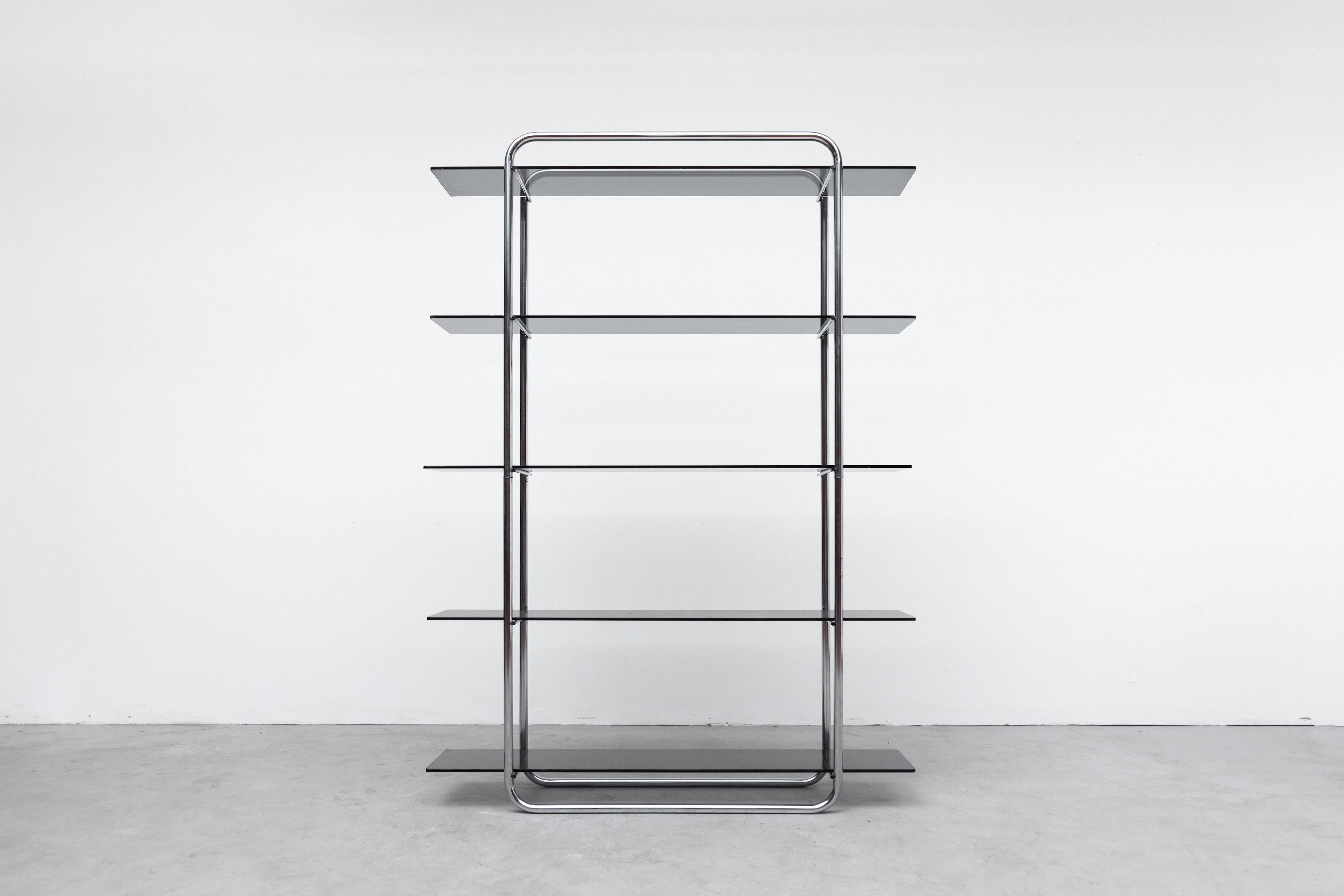 Gispen style vitrine with tubular chrome frame and smoked glass shelves. In original condition with frame wear and scratching consistent with age and use. Frame measures 35.38 x 9.5 x 70.88. Smaller matching vitrine also available (LU922423425252)