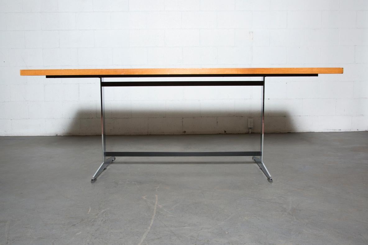 Gispen style conference table with golden Teak top and handsome chrome base. In original condition with visible wear, including some chipping to the edges of the table top. Wear is consistent with age and use.