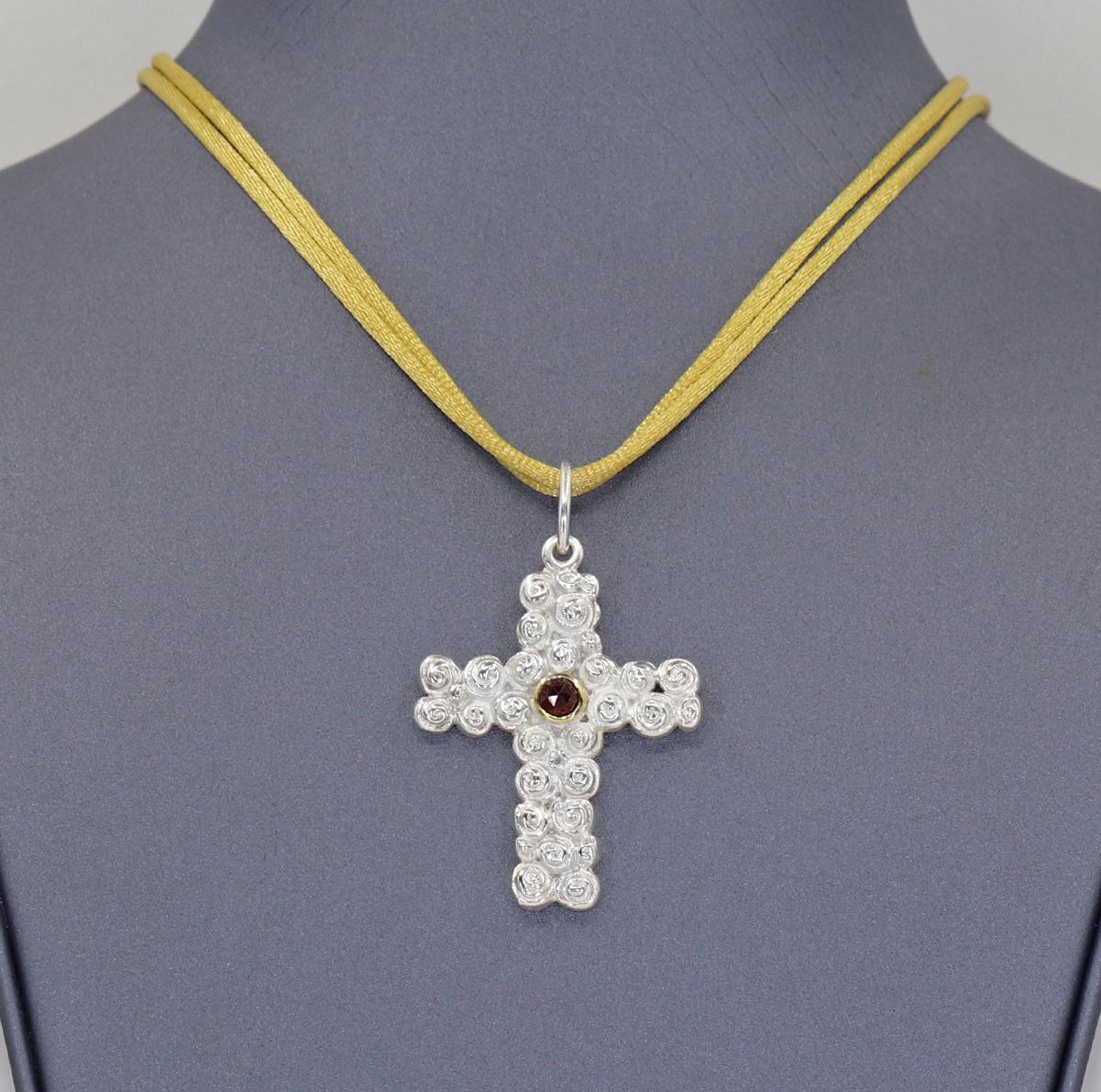 Rose Cross Pendant Necklace handcrafted in Germany by jewelry maker Gitta Pielcke in bright sterling silver with a faceted red garnet set in an 18k yellow gold bezel. Pendant accompanied with multiple neck cords in assorted colors. Stamped and