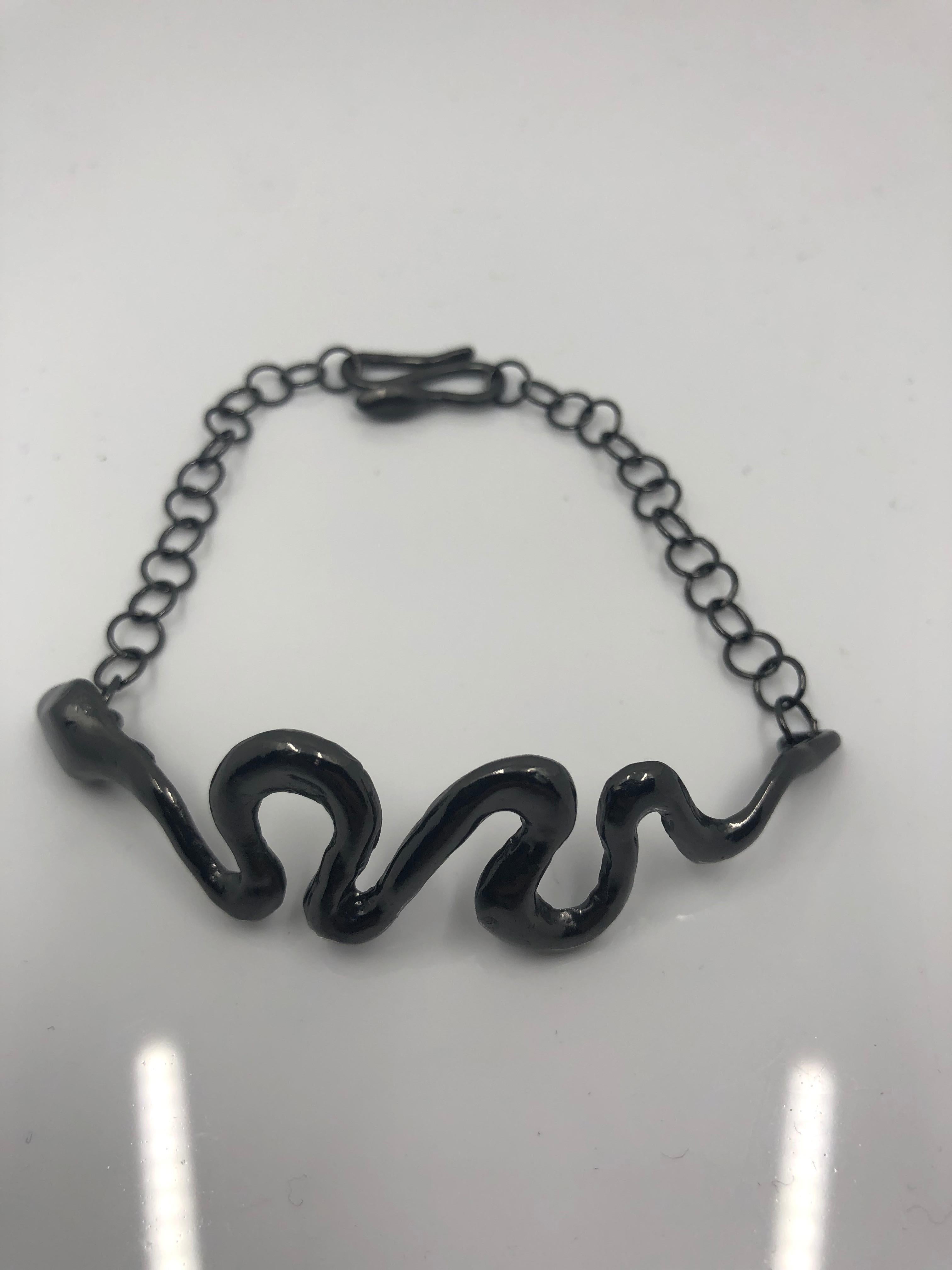 Giulia Barela’s Ribbon bracelet 

A small snake wraps around a wrist sinuously, comforting and protective.

Materials: silver and black rhodium
Weight: 18,3 gr
Lenght: 19 cm clasp included, adjustable. 