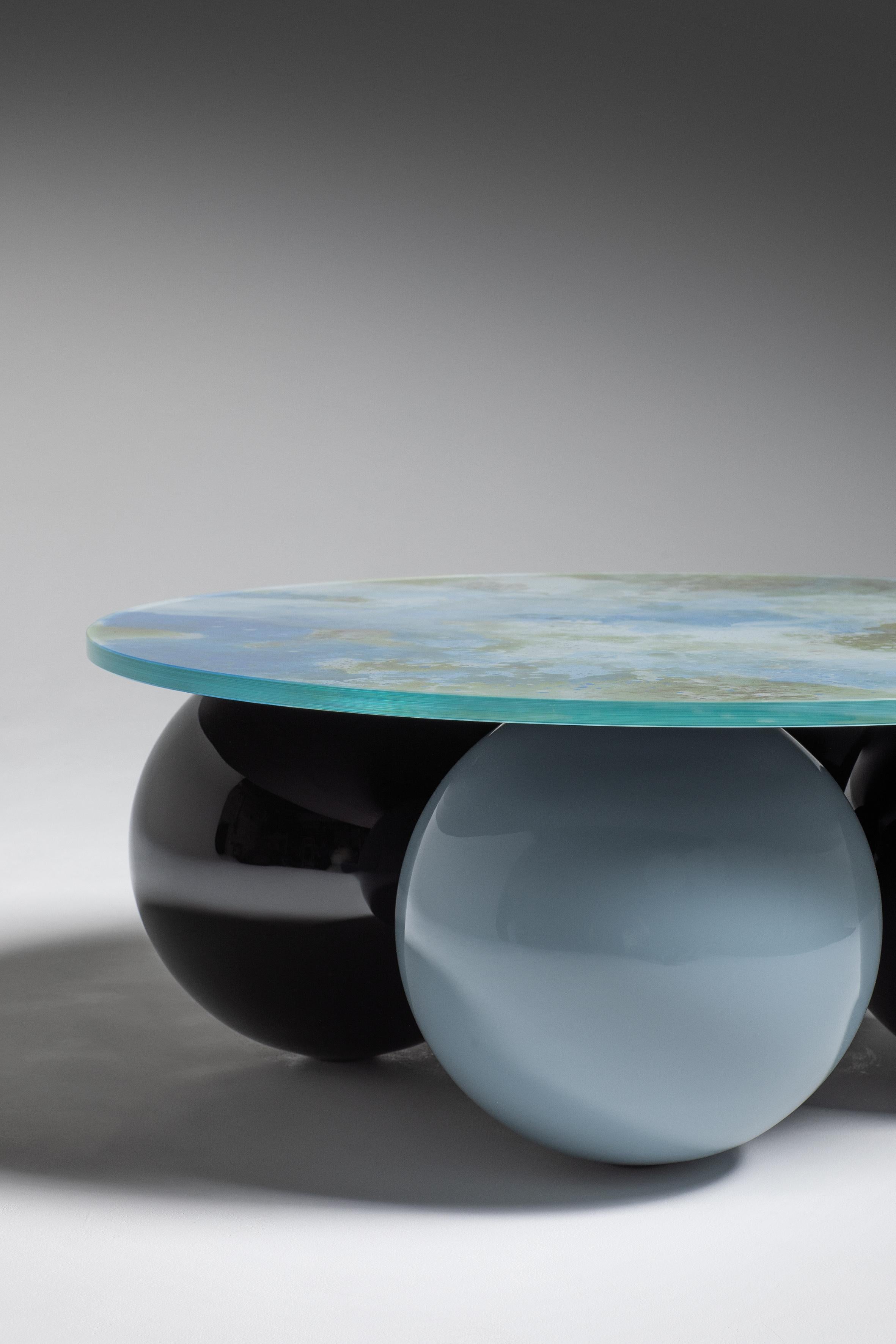 Table basse Giulia, Memphis, France, Le Berre Vevaud
Collection Empreinte
Plateau en verre églomisé (le design peut varier selon la production)
Base boule en hêtre massif, finition laquée noir brillant et gris bleu


Pour leur deuxième