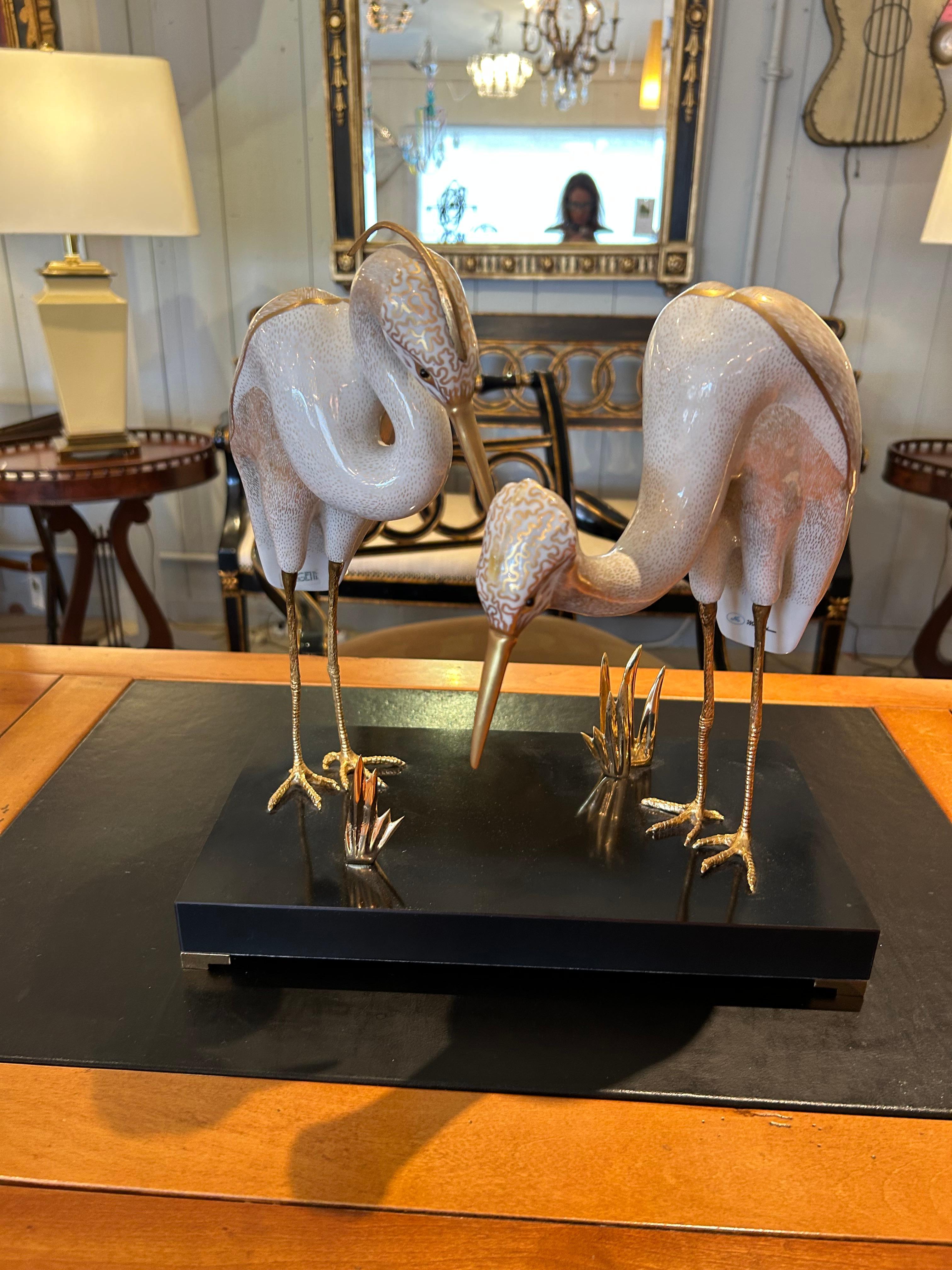 Splendida scultura di Giulia Mangani per l'azienda italiana di arredamento di alto livello Ogetti, con etichette sul pezzo.  Due bellissimi aironi dorati e decorati in porcellana con piedi dettagliati in ottone si trovano sopra una base nera con
