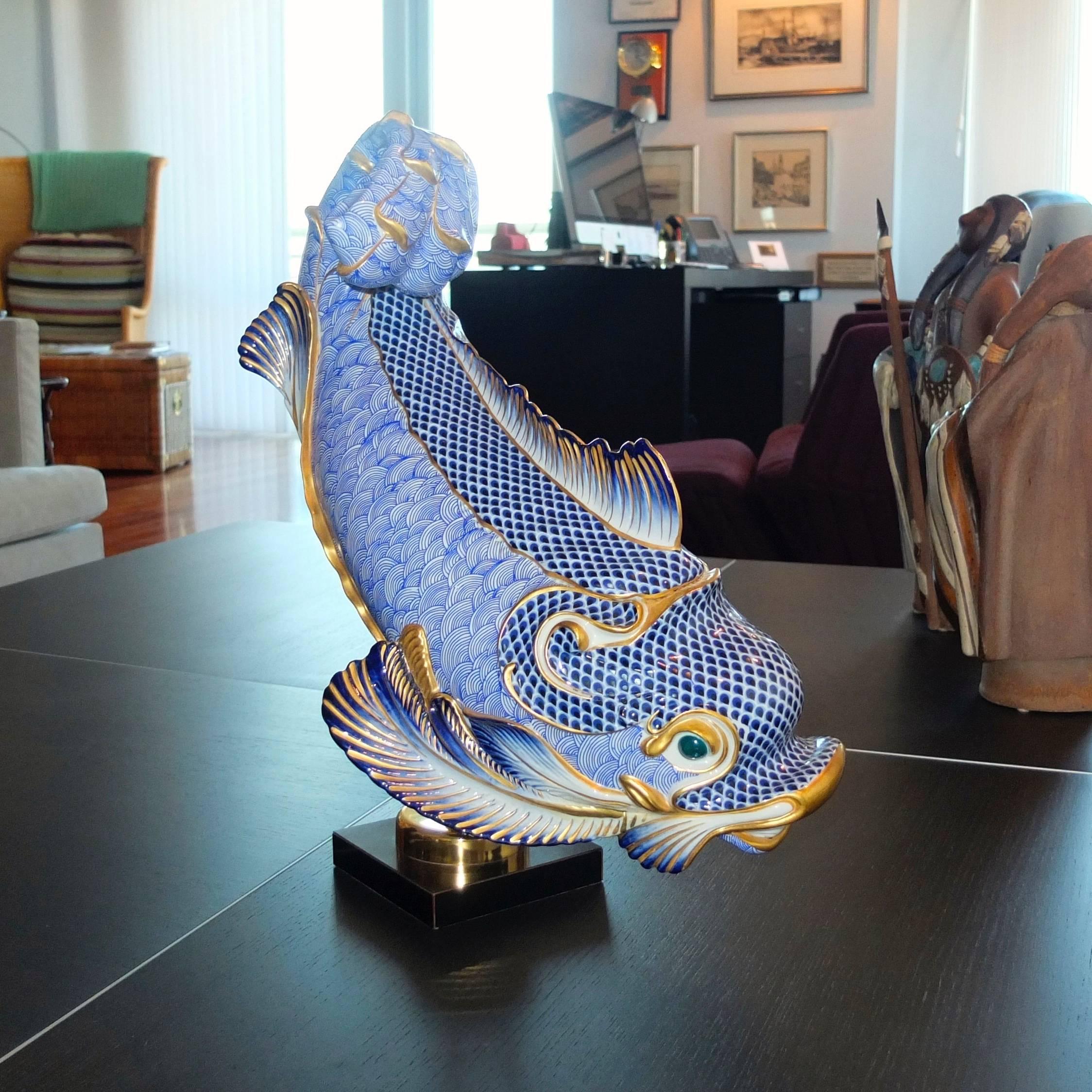 Giulia Mangani for Oggetti Italy, grand scale porcelain dolphin table sculpture, hand-painted in blue and white with 24-karat gilt detailing. Mounted on stand. 

Overall dimensions 19 1/4