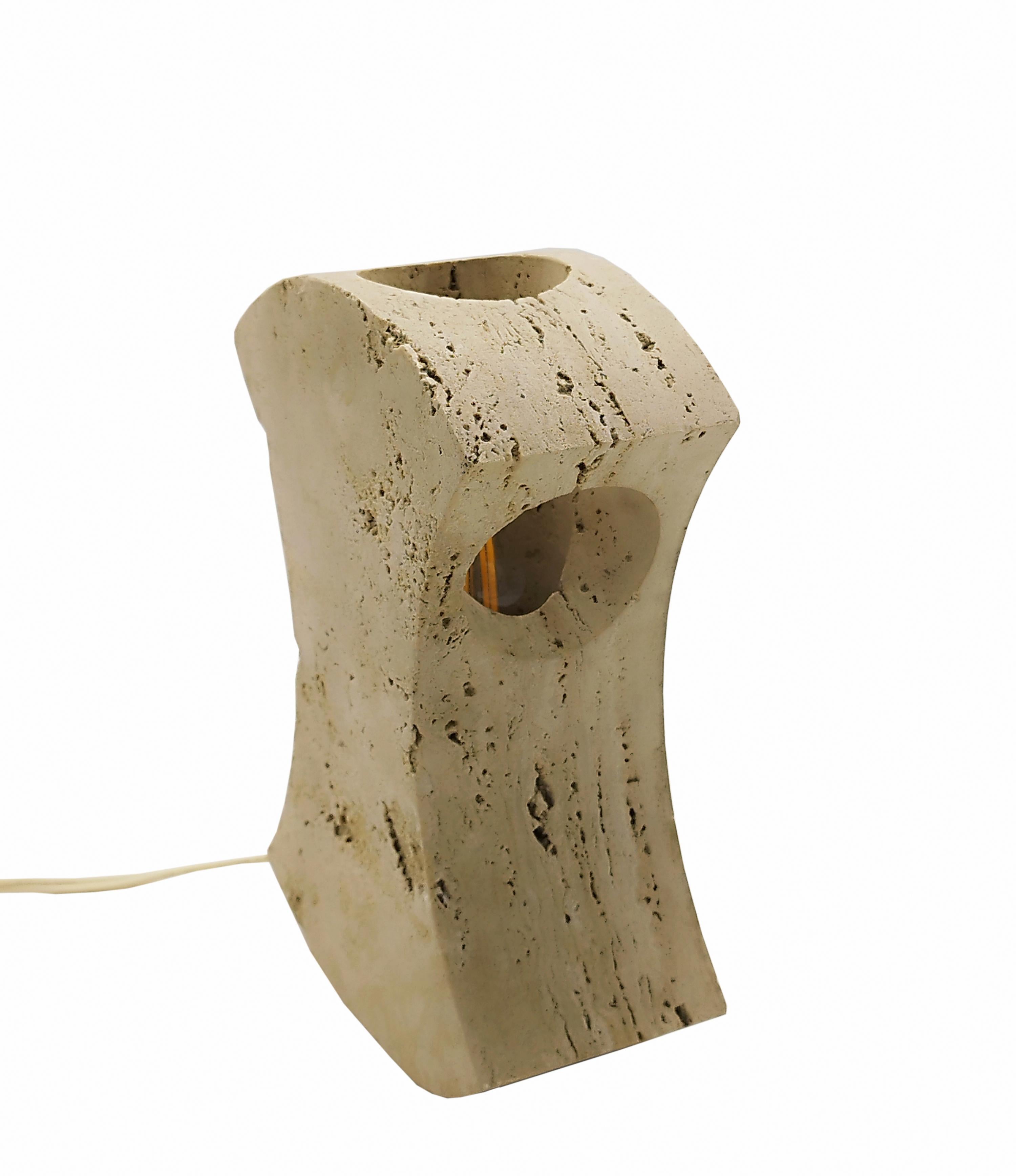 Designed around 1971 by Giuliano Cesari and Enrico Panzeri, this sculptural table lamp was made by Nucleo, a division of the Sormani furniture company in Milan, Italy. Made entirely from a single piece of travertine , the lamp boasts the