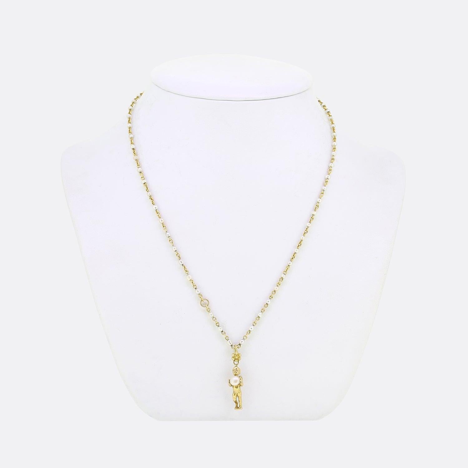 This is a fabulous antique pearl set necklace from the iconic, Carlo Giuliano. The pendant here has been crafted into a shape of an ascending cherub cradling a round button pearl. The winged figure showcases close attention to detail and hangs from