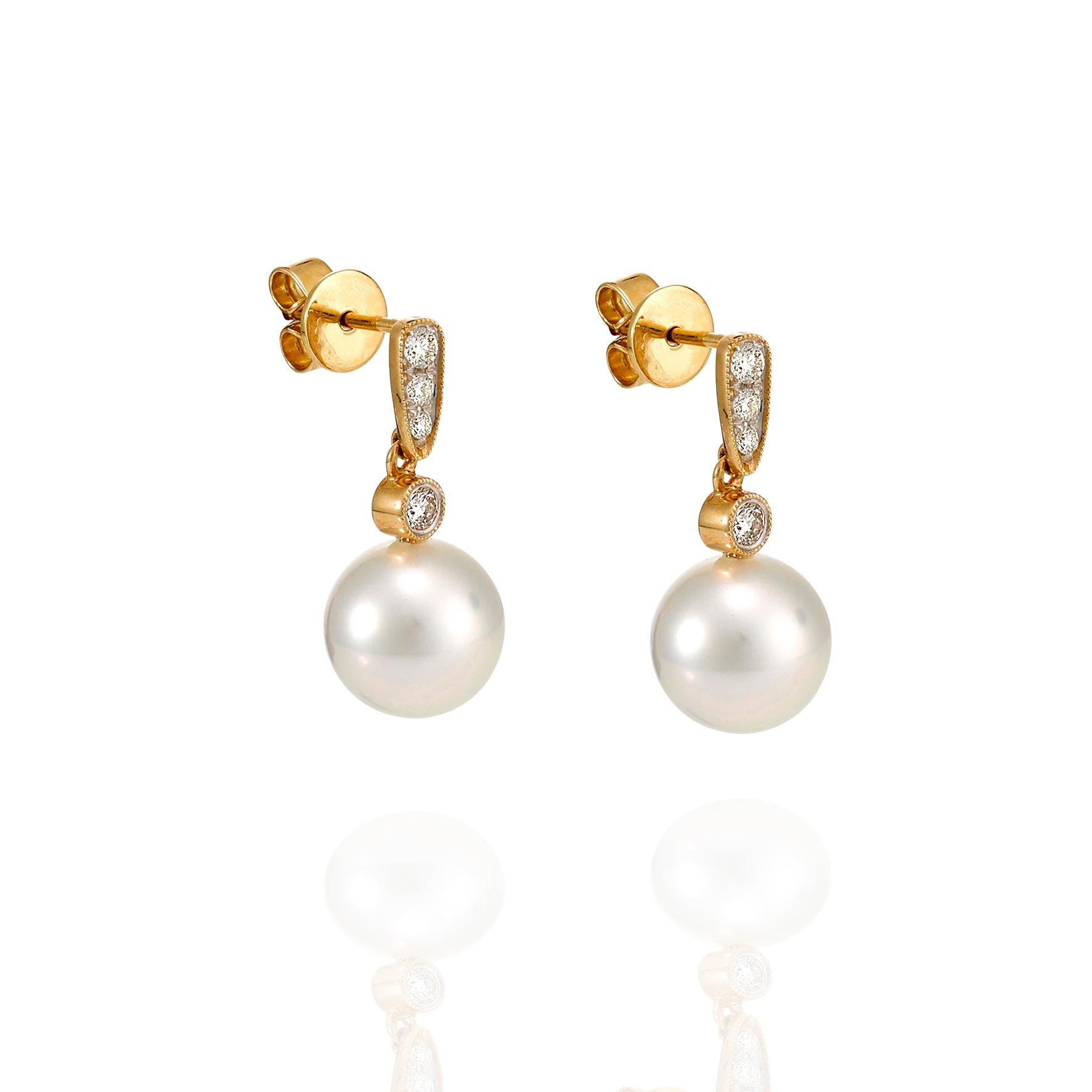 Giulians 18 karat Golden South Sea Pearl and Diamond Earrings.  Each earring features a 9.50mm round, white cultured pearl with a bright lustre and smooth surface.  The pearls have been set into 18 karat yellow and white gold and diamond drops set