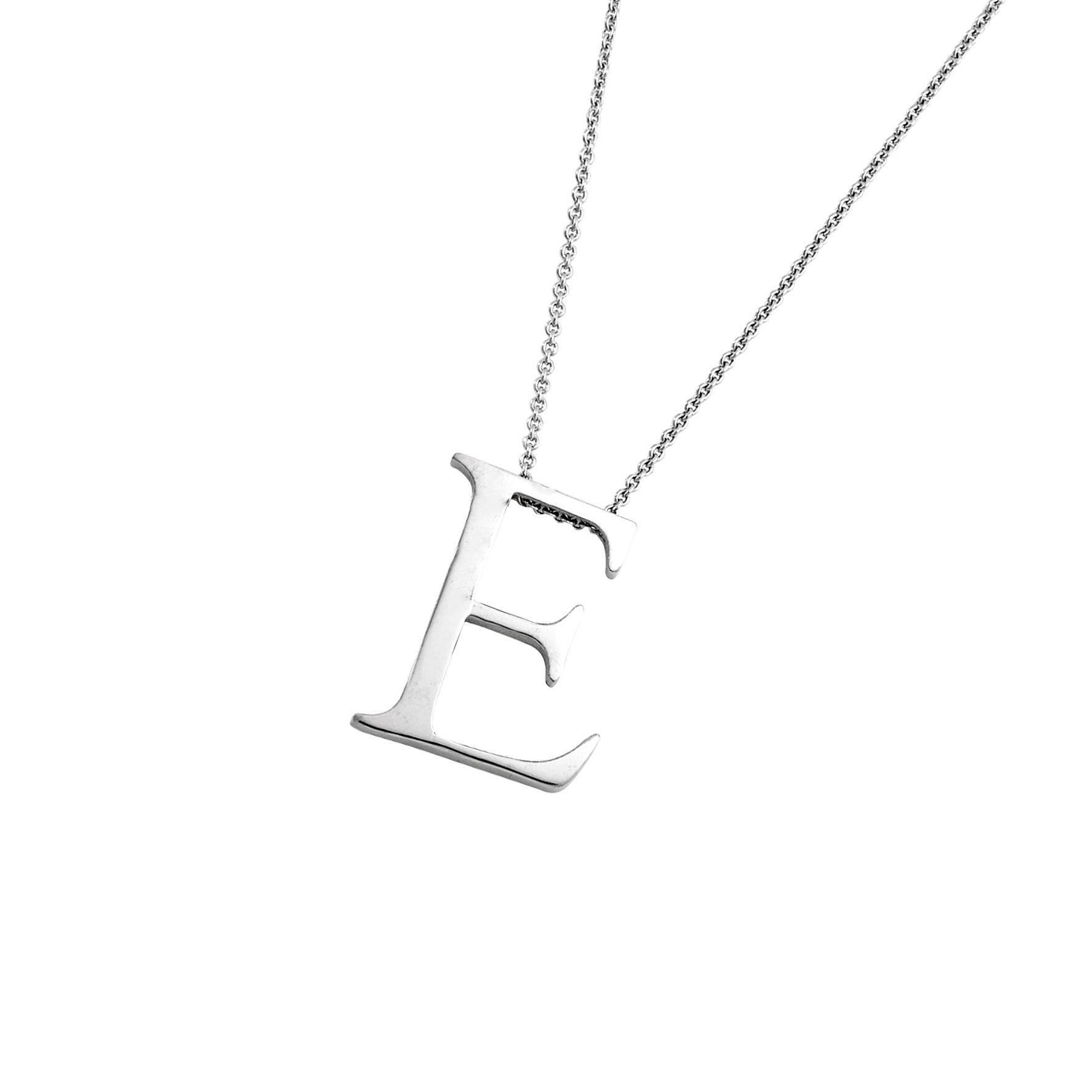 Giulians contemporary 18 karat white gold letter pendant.  This pendant features the letter E in a serif style font, with a flat profile and a polished finish.  The 18k 1mm trace chain runs through the top of the E, measuring 50 cm (19.6 inches) in
