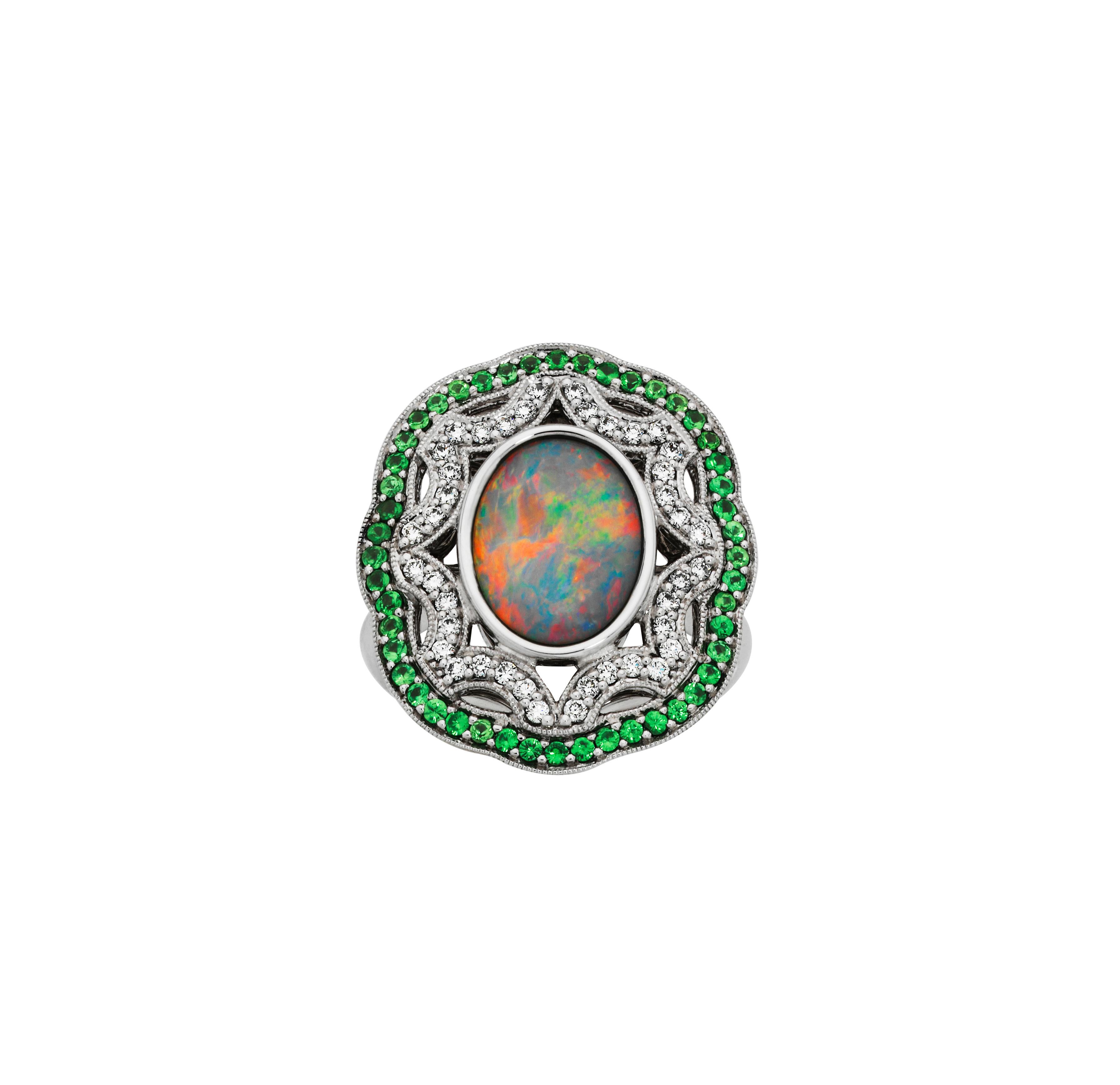 Giulians handcrafted Art Deco inspired 1.70ct light black opal, tsavorite garnet and diamond Ring.  This ring features an oval cabochon cut, natural, solid Australian black opal with bright multi-colour fire,  in an 18 karat white gold bezel