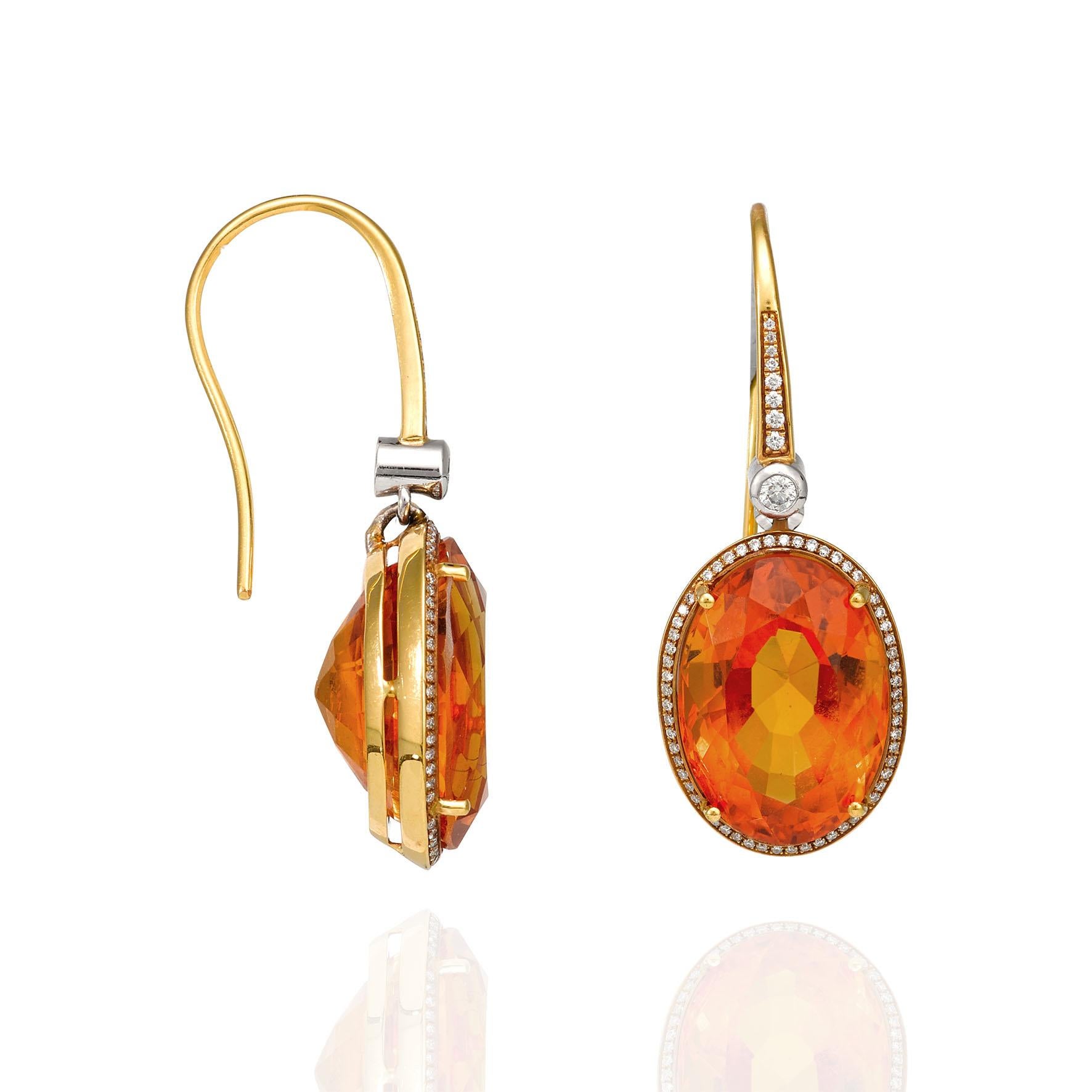 Giulians 18 karat yellow gold, citrine and diamond Earrings.  Each earring features a 9.00ct oval cut faceted citrine, prong set within a fine halo of round brilliant cut diamonds.  The pave set shepherd hook tops are articulated with a small