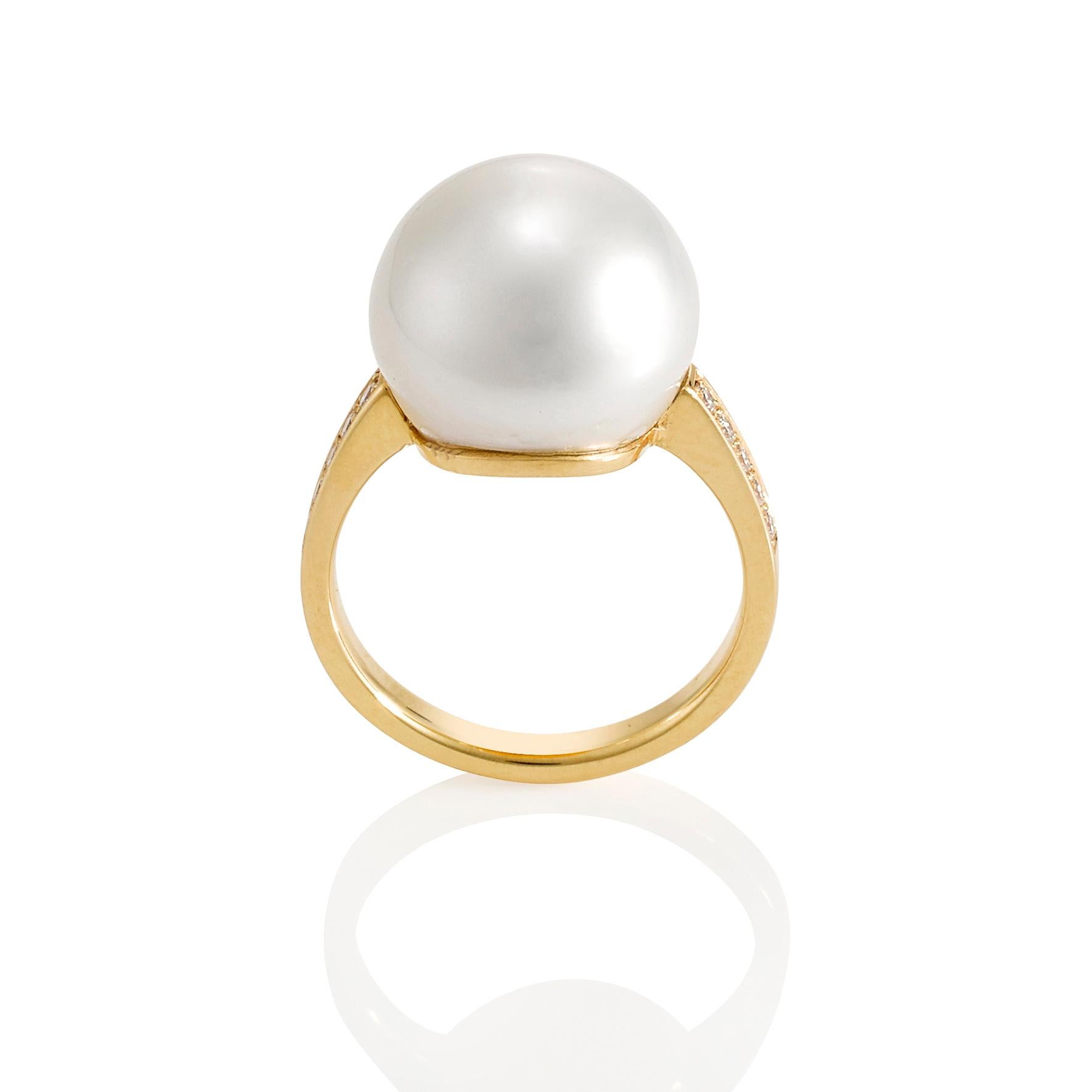 Giulians 18 karat Australian south sea pearl and diamond ring.  The ring features a 13.4mm cultured South Sea Pearl with a bright lustre.  The pearl has been hand carved to sit lower on the finger.  The parallel band has been theadset with 12 round