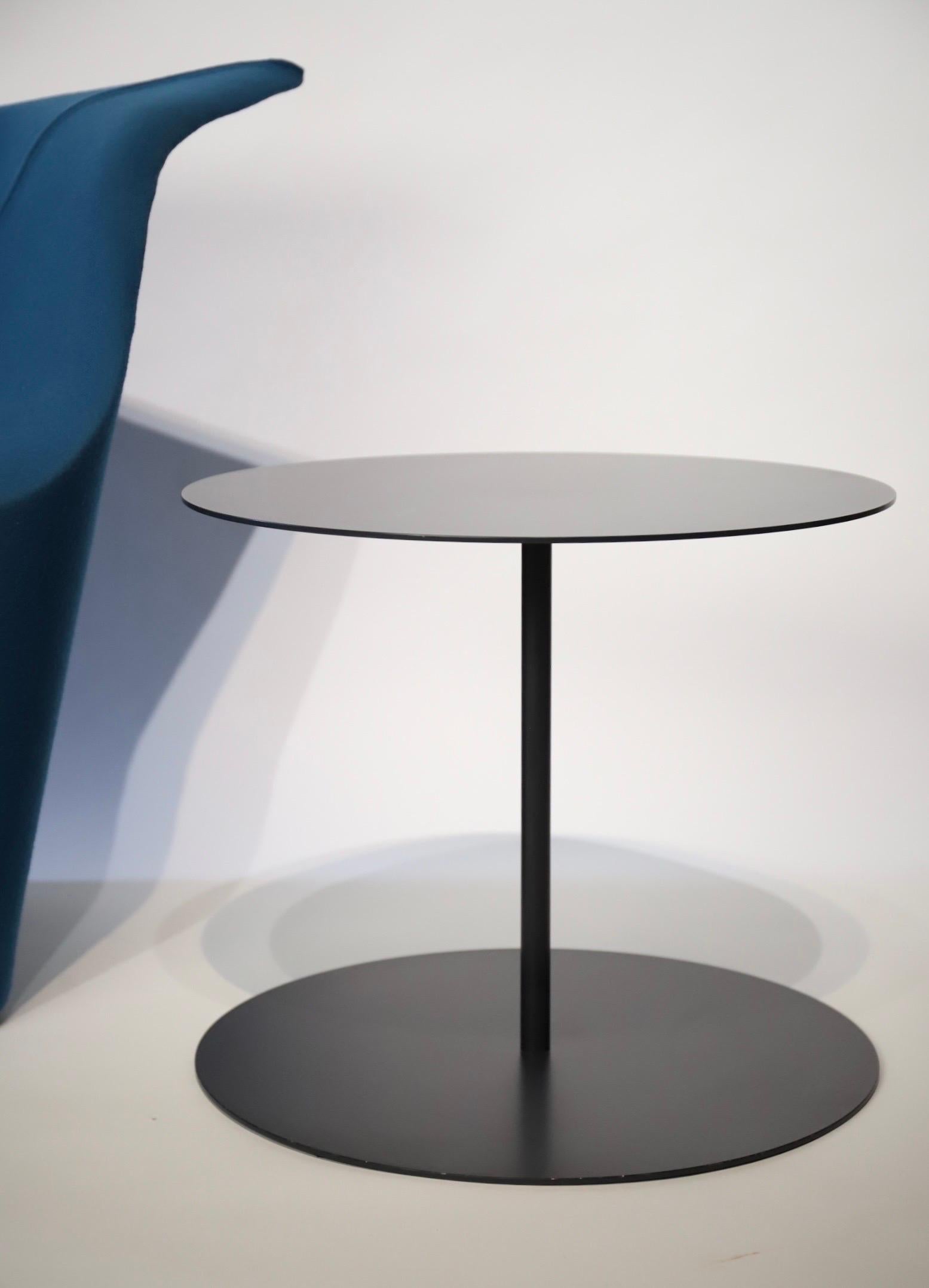 The gong table is a signature design by Giulio Cappellini. The round top is made of laser-cut sheet metal, connected to the base with a tubular iron leg. Great as an end table or a small single coffee table. Color is a dark blueish/grey black.