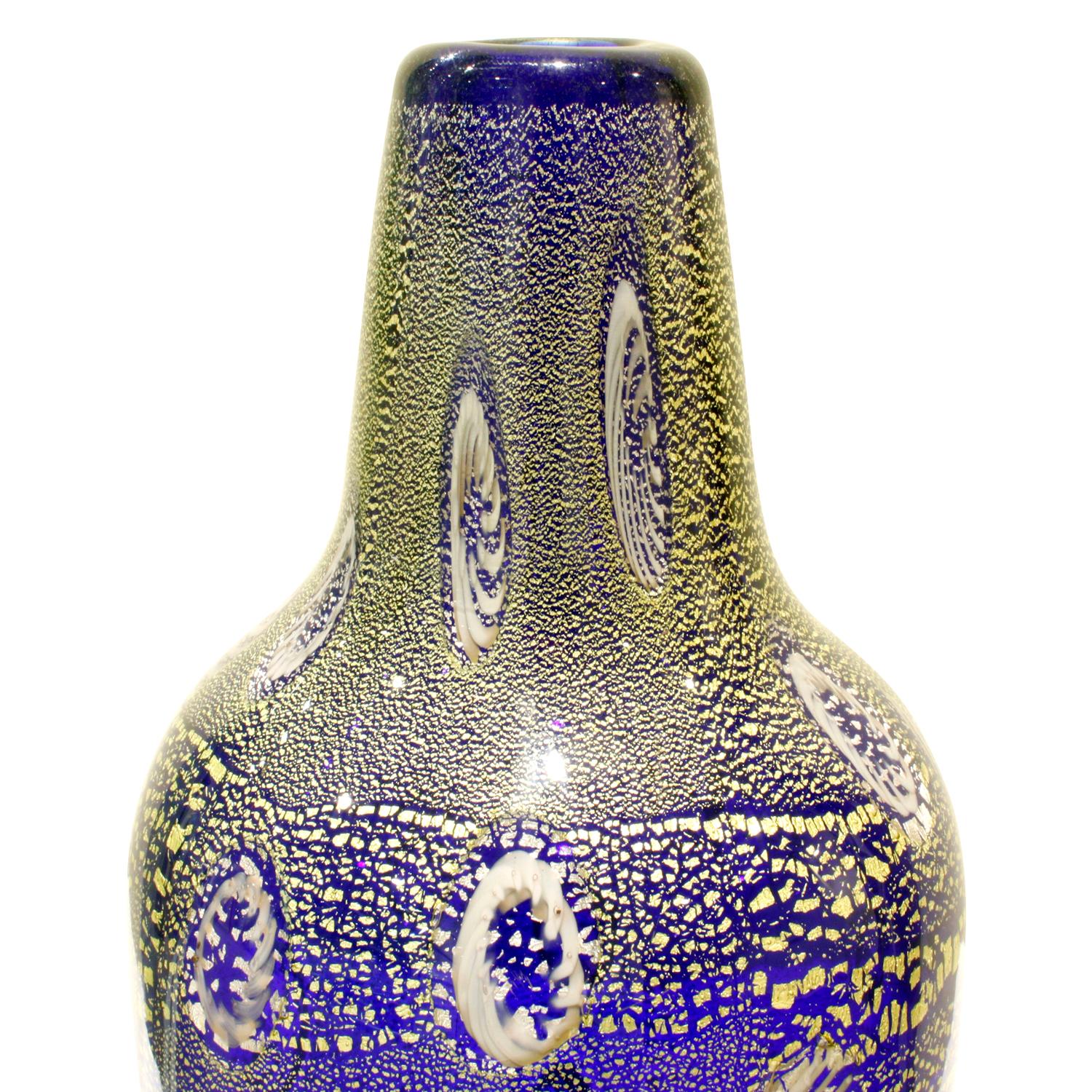 Hand blown blue glass vase with murrhines and gold foil by Giulio Radi for Arte Vetraria Muranese (A.V.E.M.), Murano, Italy, circa 1950. Radi's works are beautiful and rare. The gold foil in the glass give it a jewel-like quality.

Reference:
