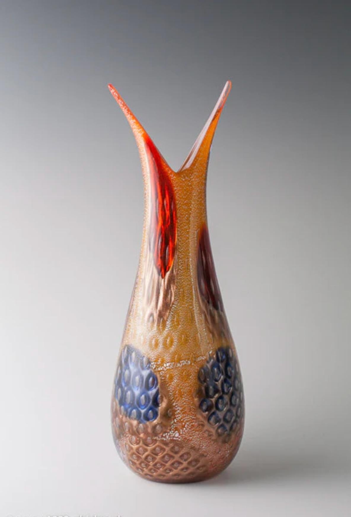 Giulio Radi (1895-1952), grande vaso, 1950 ca.
lamina d'oro e d'argento, avventurina e murrine grandi e multicolori su fondo bianco/arancio
prodotto da Arte Vetraria Muranese (A.VE.M.), Murano, Italia
47 cm (altezza) 
non marcato

condizioni