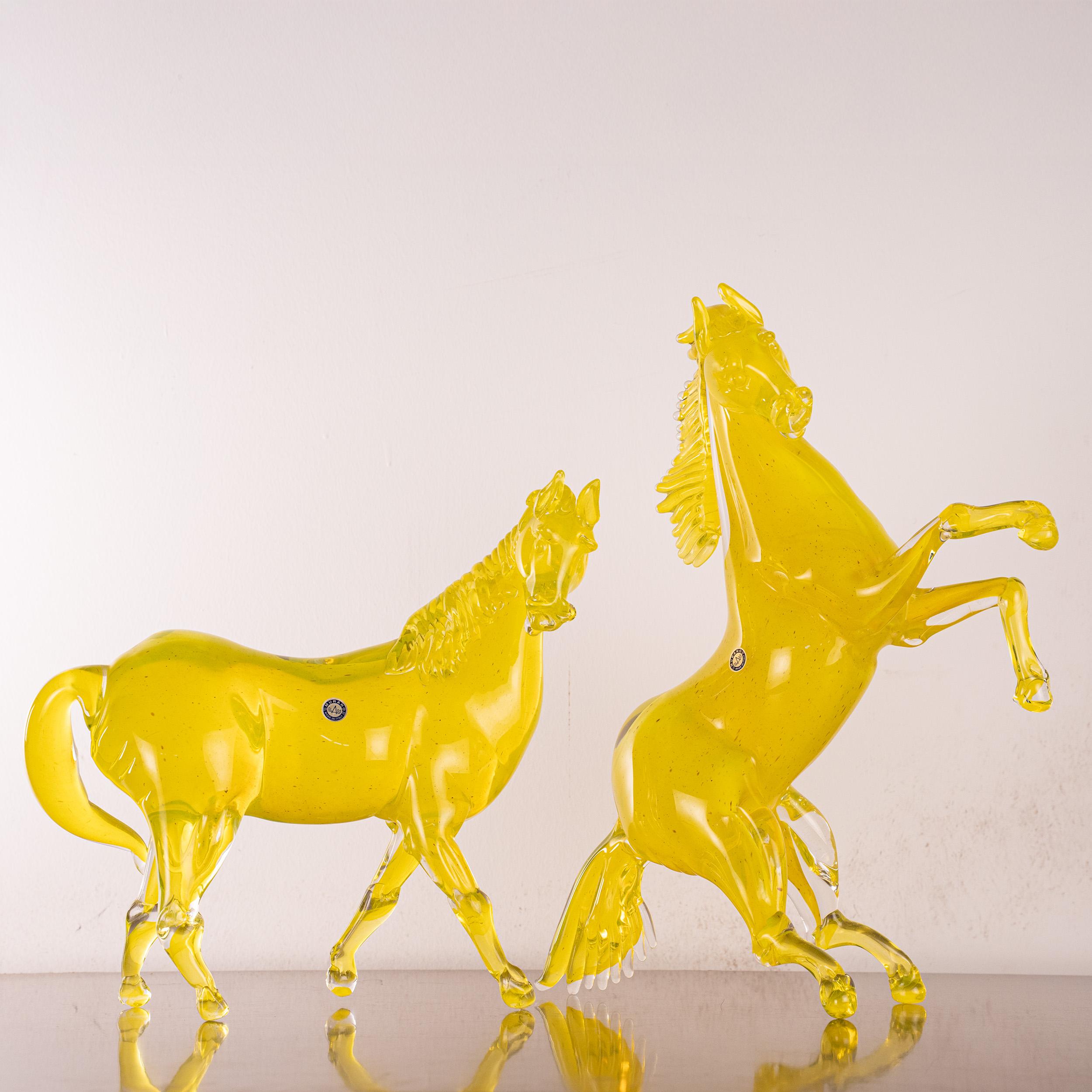 Una coppia di sculture di cavalli in vetro di Murano del maestro veneziano Giuman, di grande impatto visivo, realizzate in un raro e vibrante vetro giallo sole a corpo intero.
Il colore è un giallo Murano puro e saturo, luminoso e brillante,