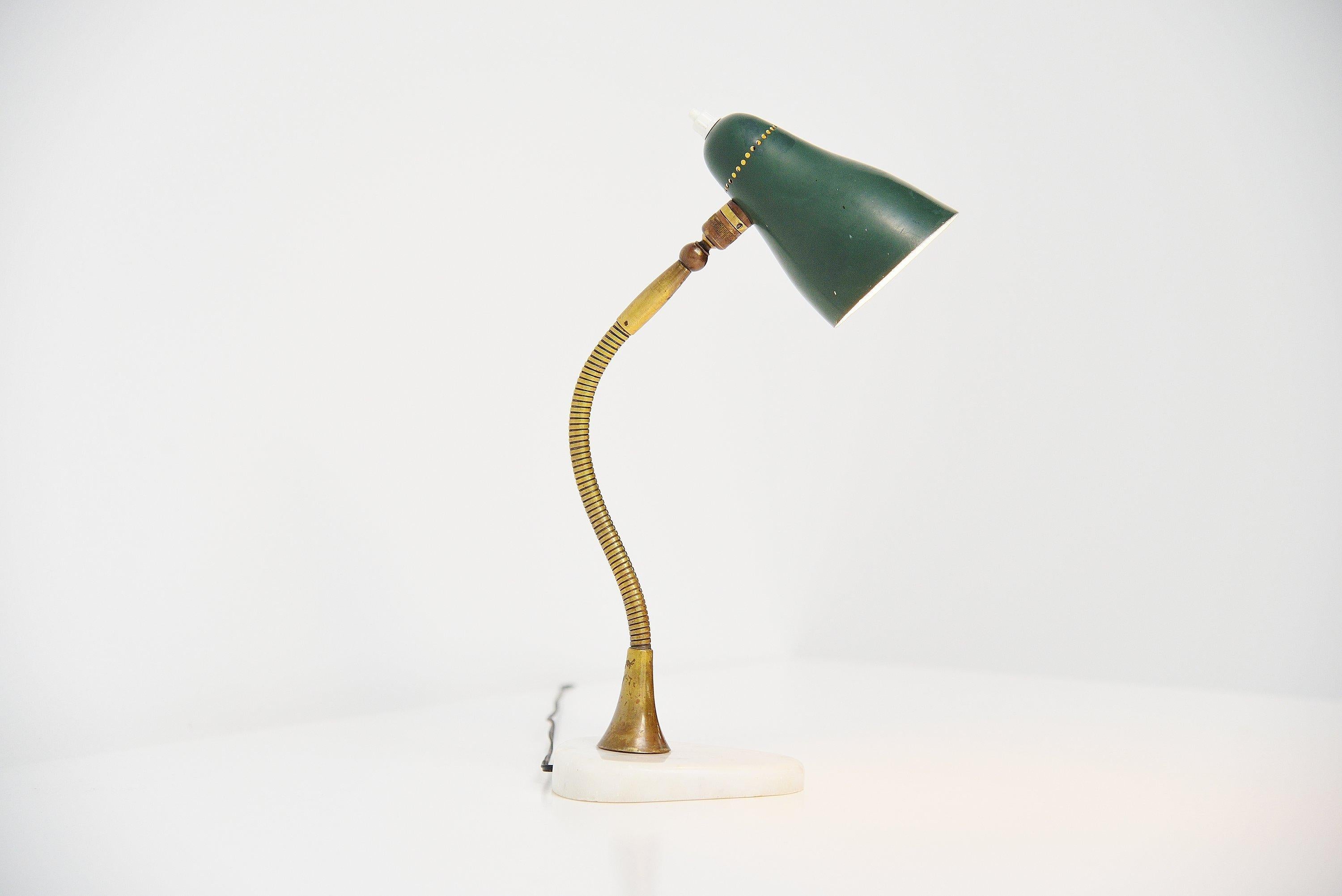 Nice adjustable small table lamp attributed to Giusepp Ostuni and manufactured by Oluce, Italy 1955. The table lamp has a very nice shaped marble base which has a small chip to it. It has a brass bendable arm and a green aluminium shade with on/off