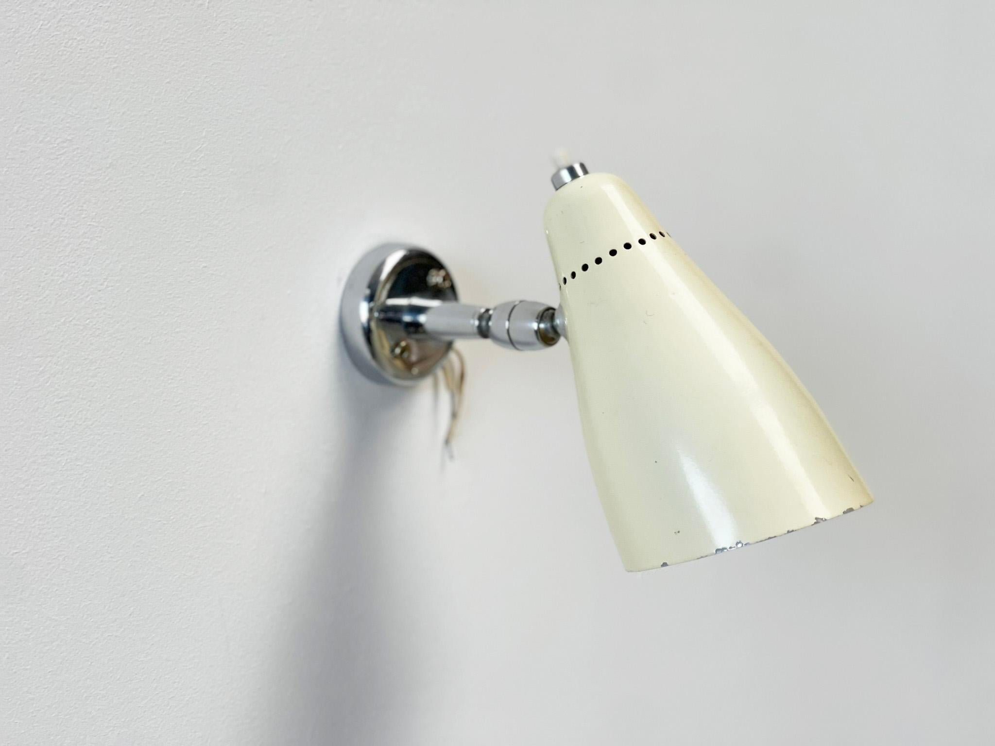 Nice wall lamp designed by Giuseppe Ostuni . These are typical elegant lamps from the 50's. This one has a very nice white enamel shade with chrome wall bracket. 

This is a very good example of the typical 50's Italian lamps