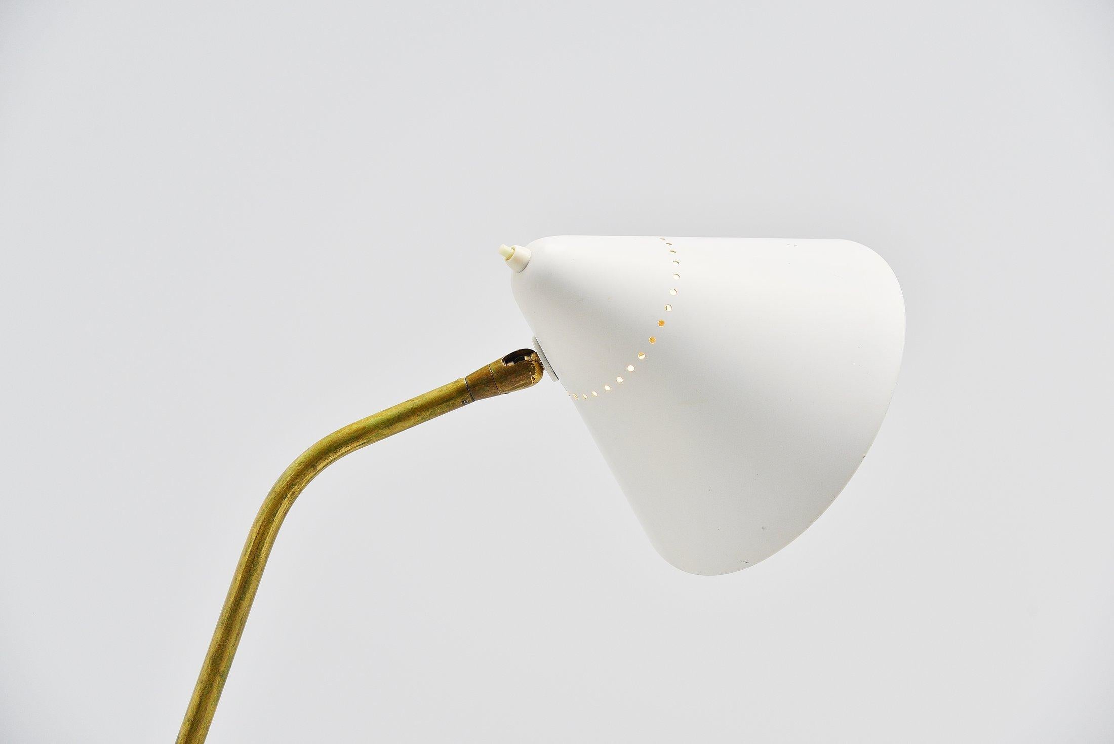 Very nice and sophisticated floor lamp designed by Giuseppe Ostuni and manufactured by Oluce, Italy, 1952. This lamp has a stem that is adjustable in angle and the shade is as well. Very nice solid brass stem with and of white aluminum shade and