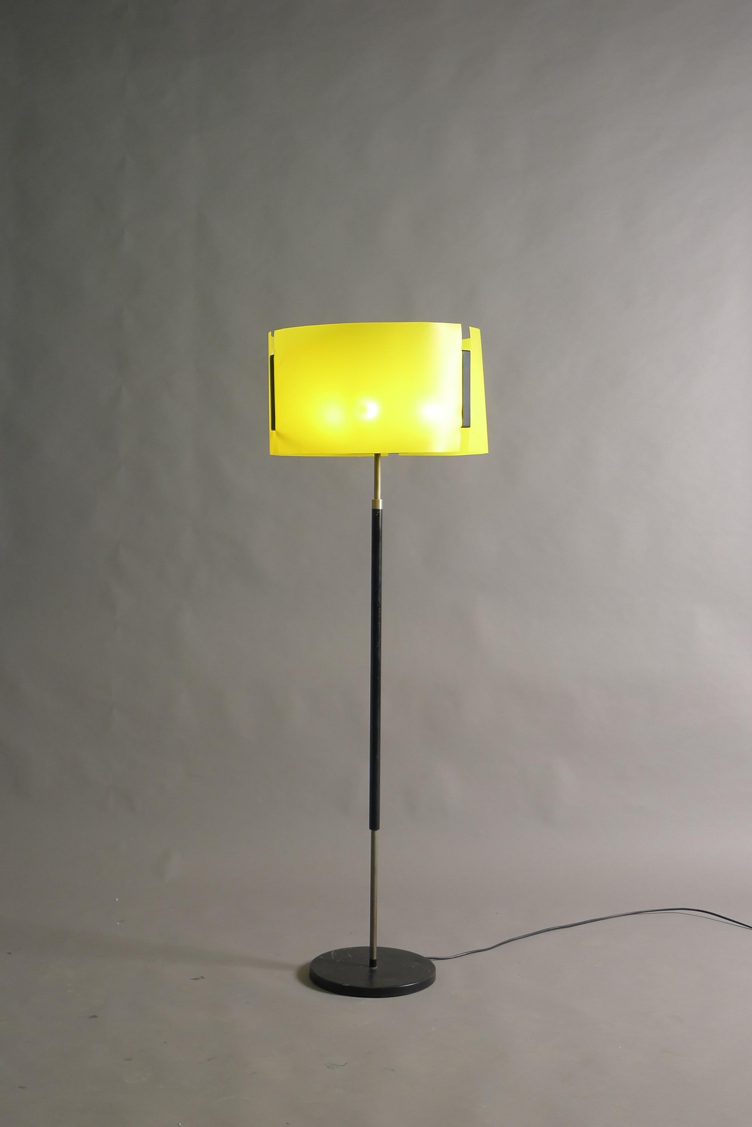Giuseppe Ostuni for Oluce, Italy circa 1960. A floor lamp with enamelled metal black base, stem supporting black metal framework with yellow flexi shade. Inside there are 3 vertical light sources and a central uplighter, these are switched