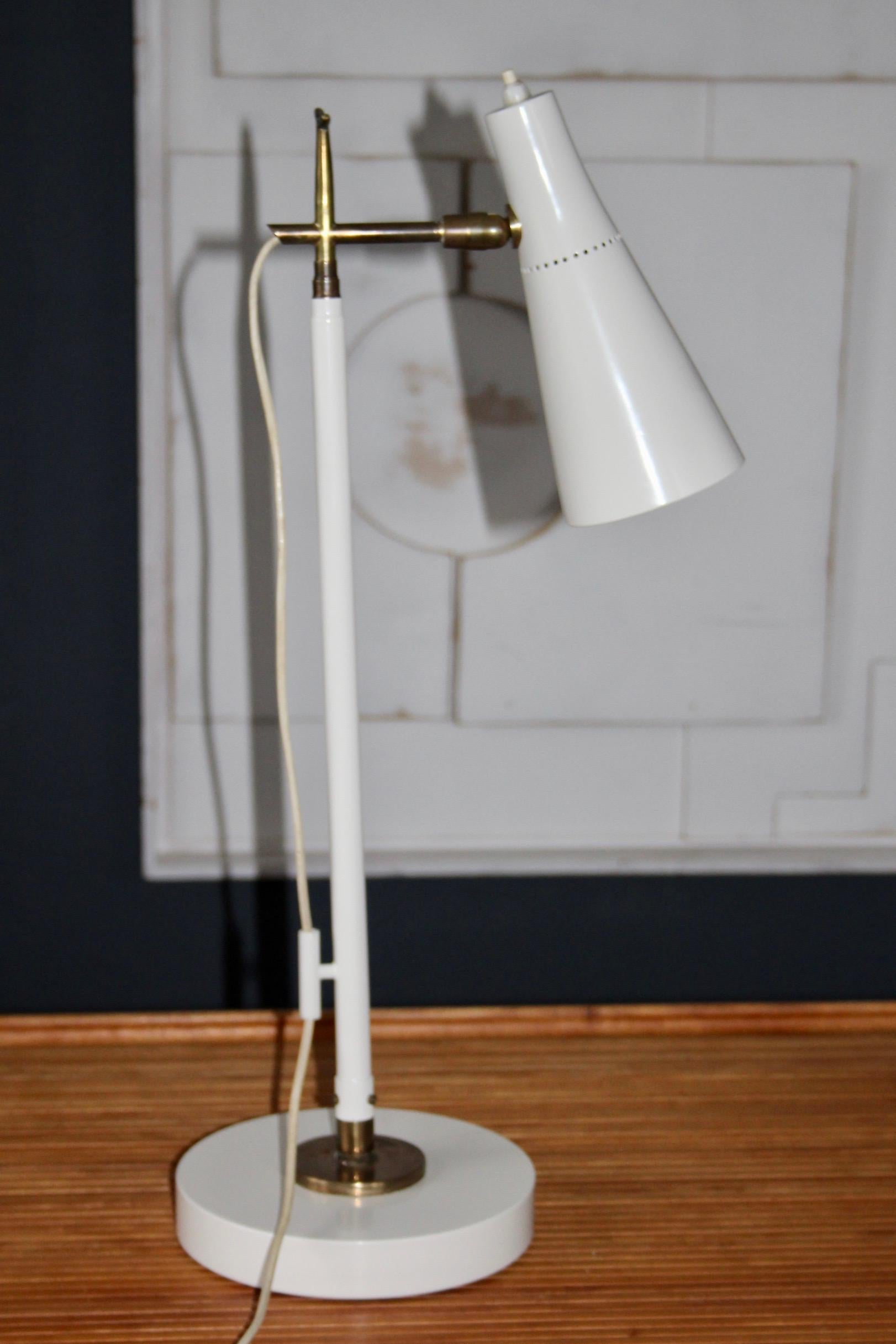 Rare piece, this floor lamp (and table lamp) model 201 was designed by Giuseppe Ostuni in 1952 in Italy and then published by Oluce. It is composed of a circular base, an arm with adjustable height from 57 to 153 cm and a lampshade, all in white