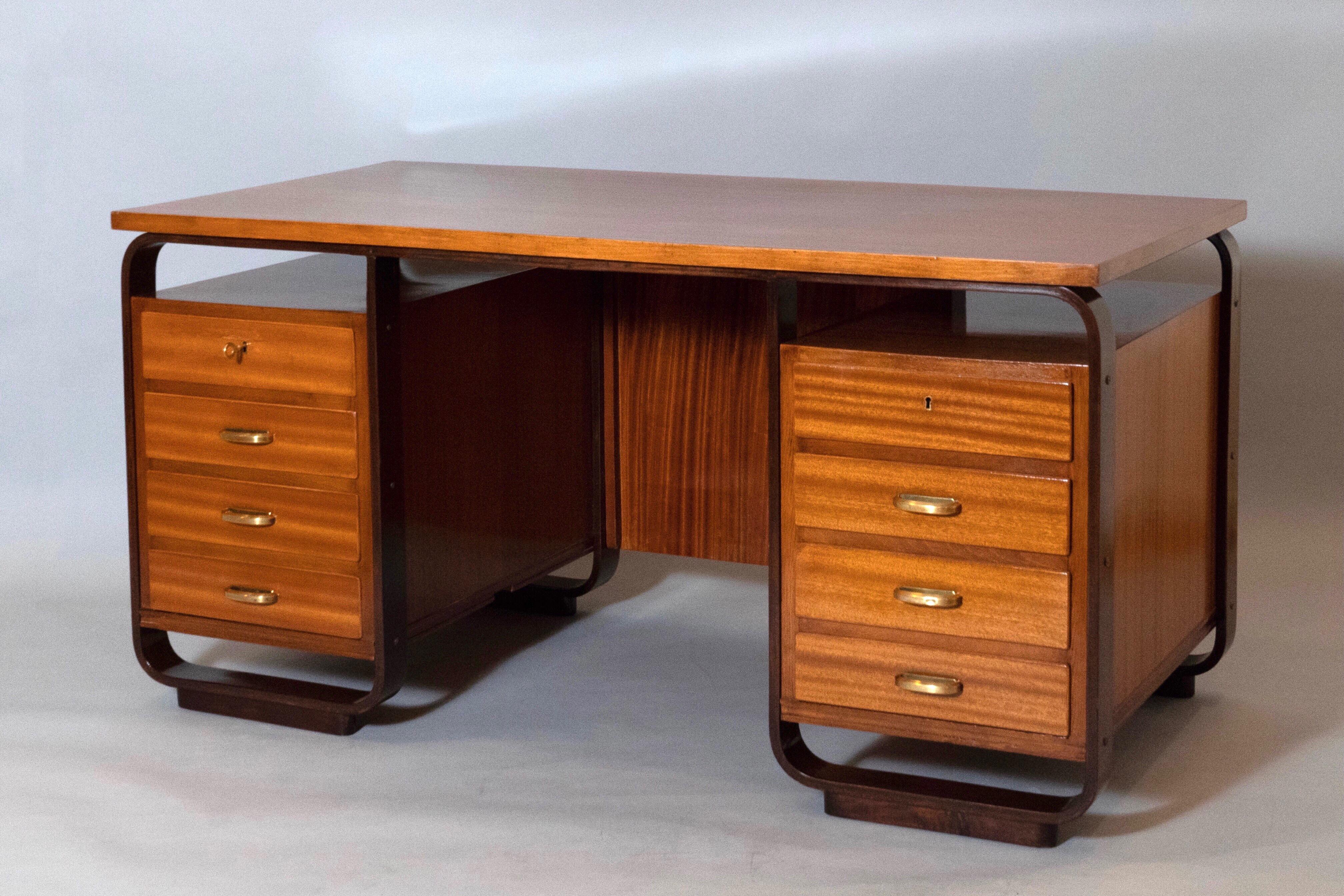 Giuseppe Pagano (1896 - 1945) 

An imposing eight-drawer desk by rationalist architect and designer Giuseppe Pagano, in fruitwood with mahogany-stained trim and polished brass handles. 

Italy, 1940.