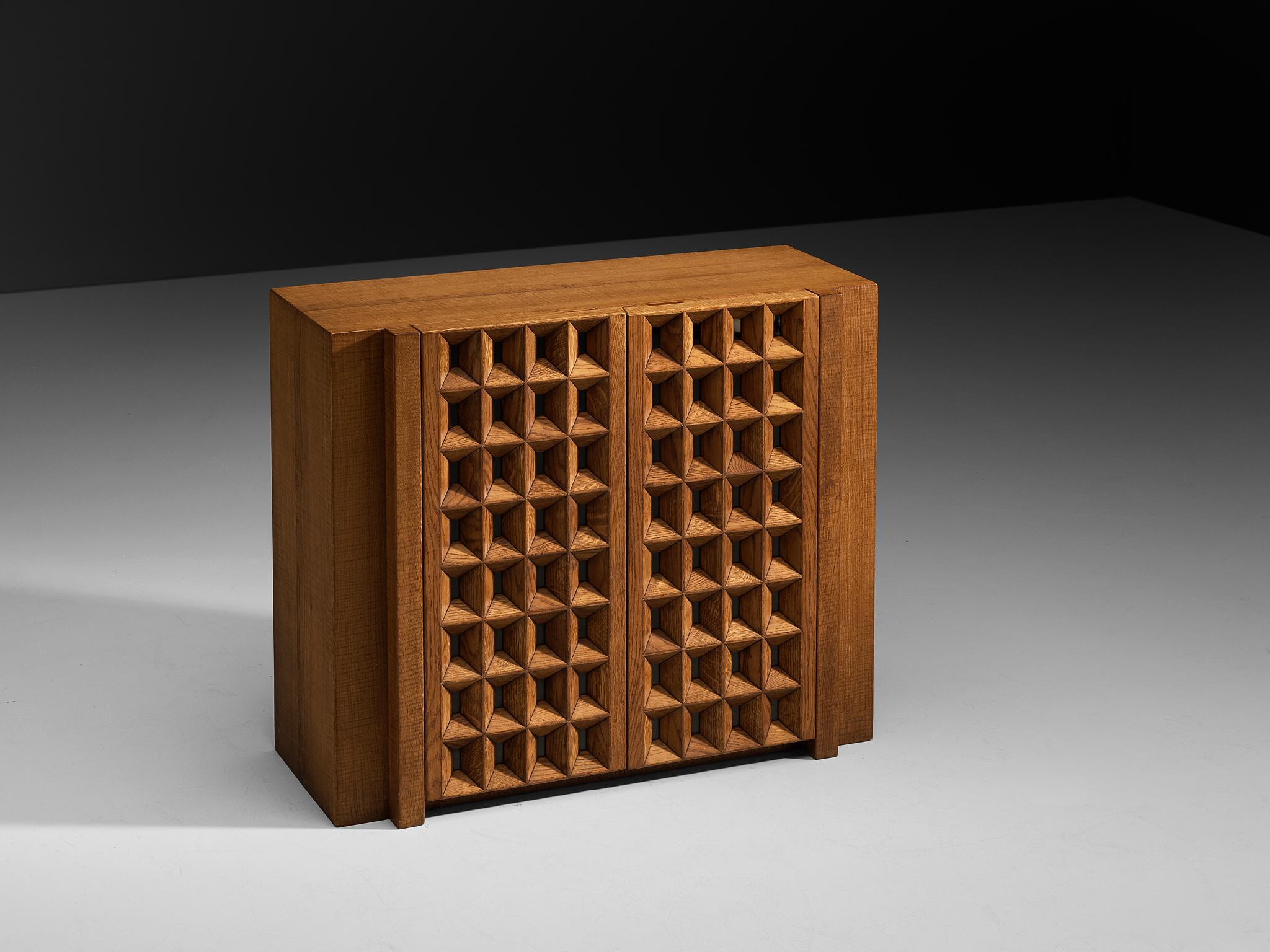 Giuseppe Rivadossi for Officina Rivadossi, cabinet, oak, Italy, 1970s

An exceptional cabinet by the Italian sculptor and designer Giuseppe Rivadossi, exemplifying outstanding woodwork. Taking center stage are the square carved cutouts paired with