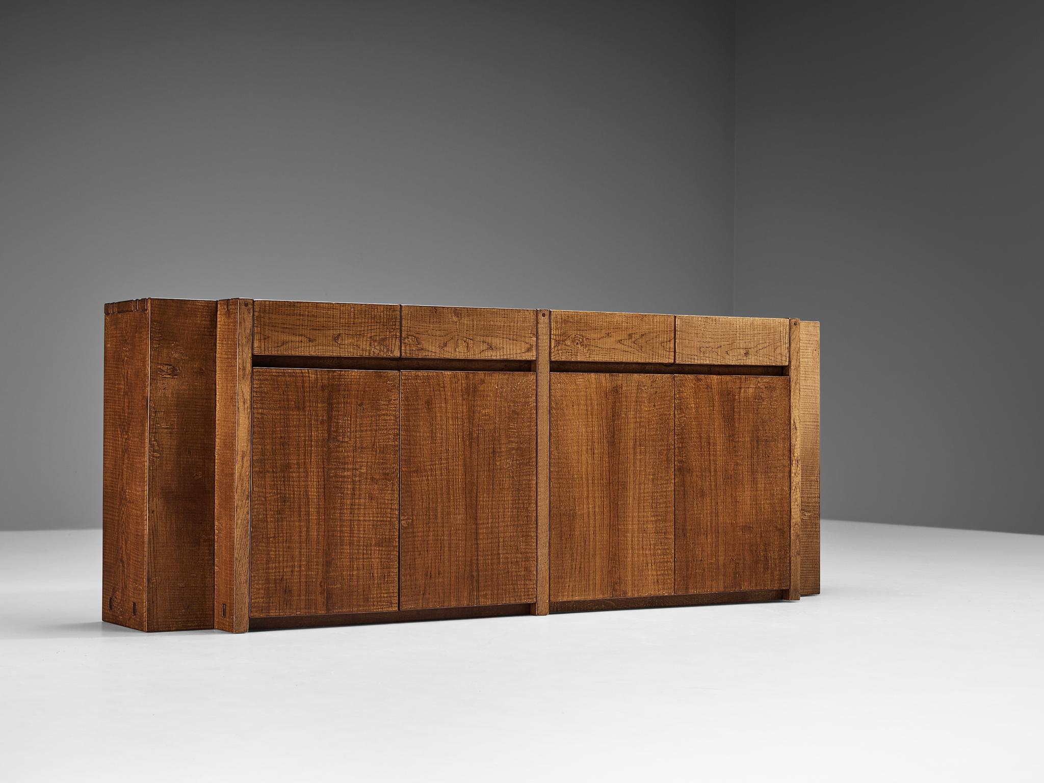 Giuseppe Rivadossi for Officina Rivadossi, sideboard, oak, Italy, 1980s.

Giuseppe Rivadossi once again proves his great eye for materialization and technicality that this design is exemplary for. The sideboard is constructed using wooden panels