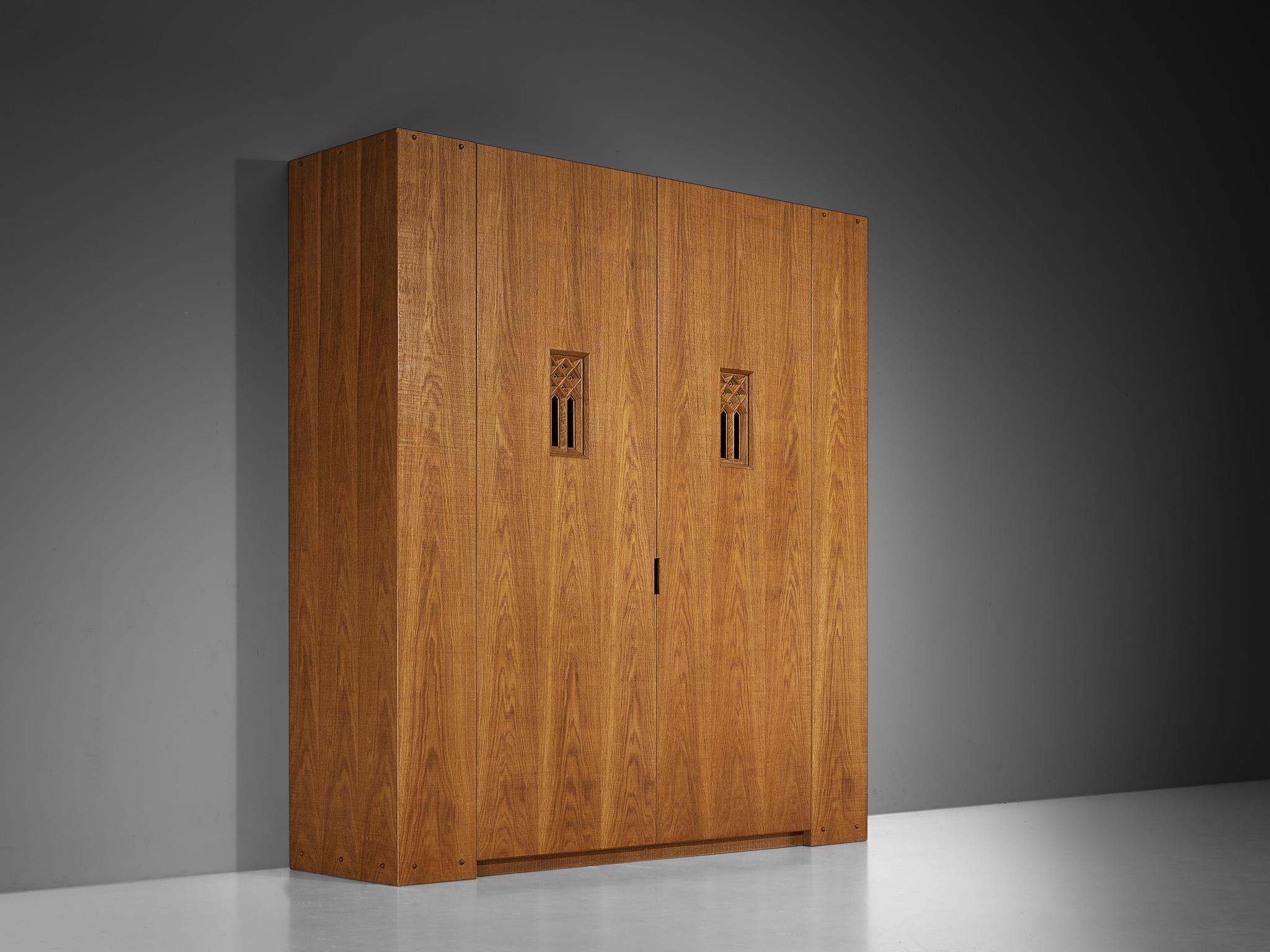 Giuseppe Rivadossi, wardrobe, oak, glass, Italy, 1970s 

An extraordinary grand armoire by Italian sculptor and designer Giuseppe Rivadossi, showcasing exquisite woodworking skills. A standout feature is the pair of rectangular carved insets with