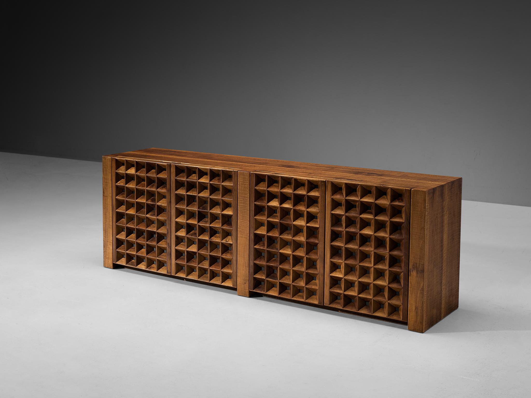Giuseppe Rivadossi for Officina Rivadossi, sideboard, walnut, glass, Italy, 1980s

An exceptional credenza by the Italian sculptor and designer Giuseppe Rivadossi, featuring a high level of craftsmanship in woodwork. The door panels feature square